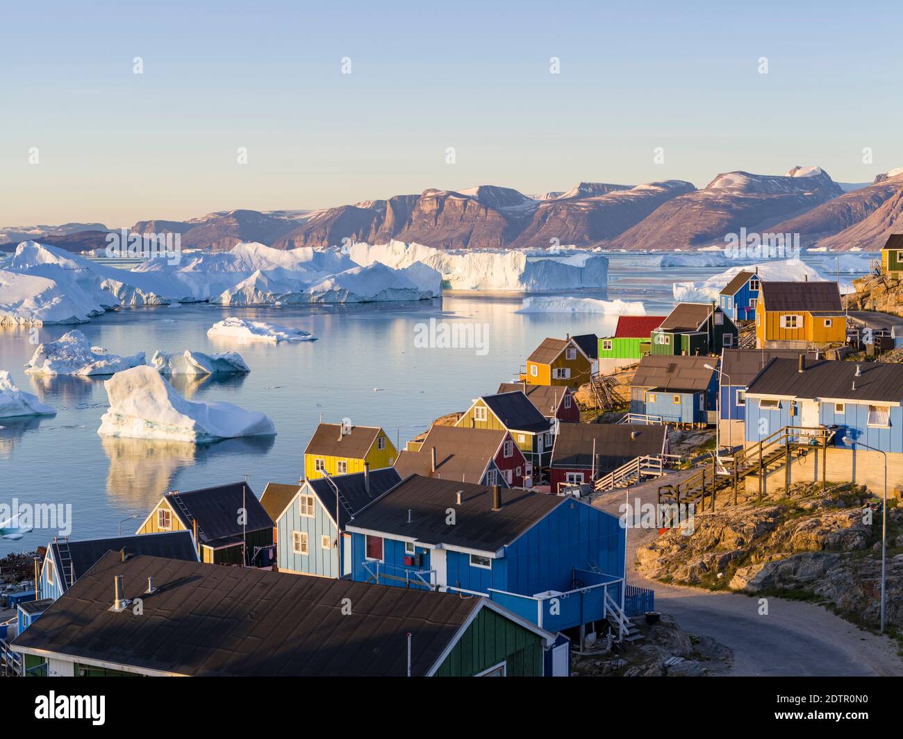 View of fjord full of icebergs towards Nuussuaq (Nugssuaq) peninsula during midnight sun. The town Uummannaq in the north of West Greenland, located o Stock Photo