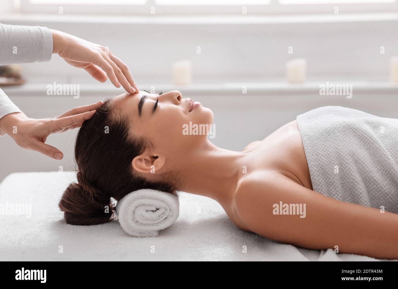 Attractive korean woman enjoying acupressure face massage procedure at