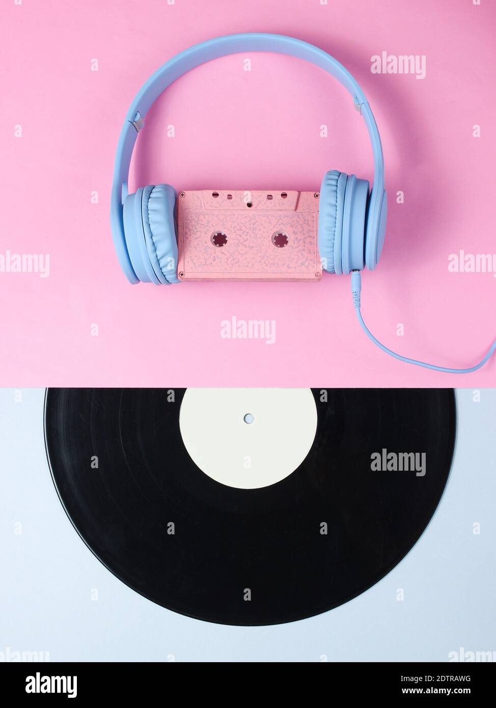 Minimalism. Retro style. Headset with audio cassette, lp record on pink ...