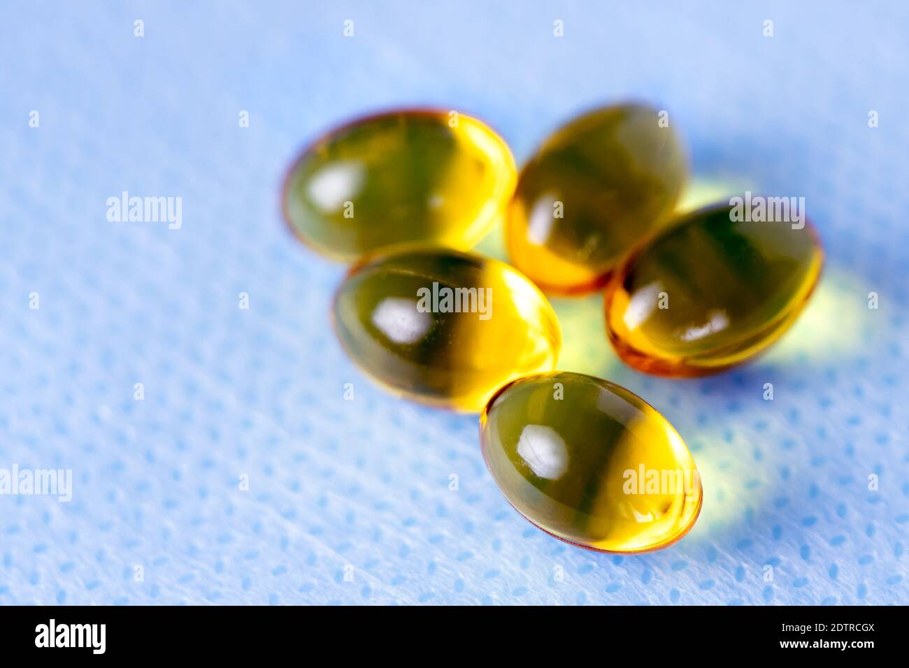 Yellow capsules of vitamin D, macro close-up of golden pills Stock Photo