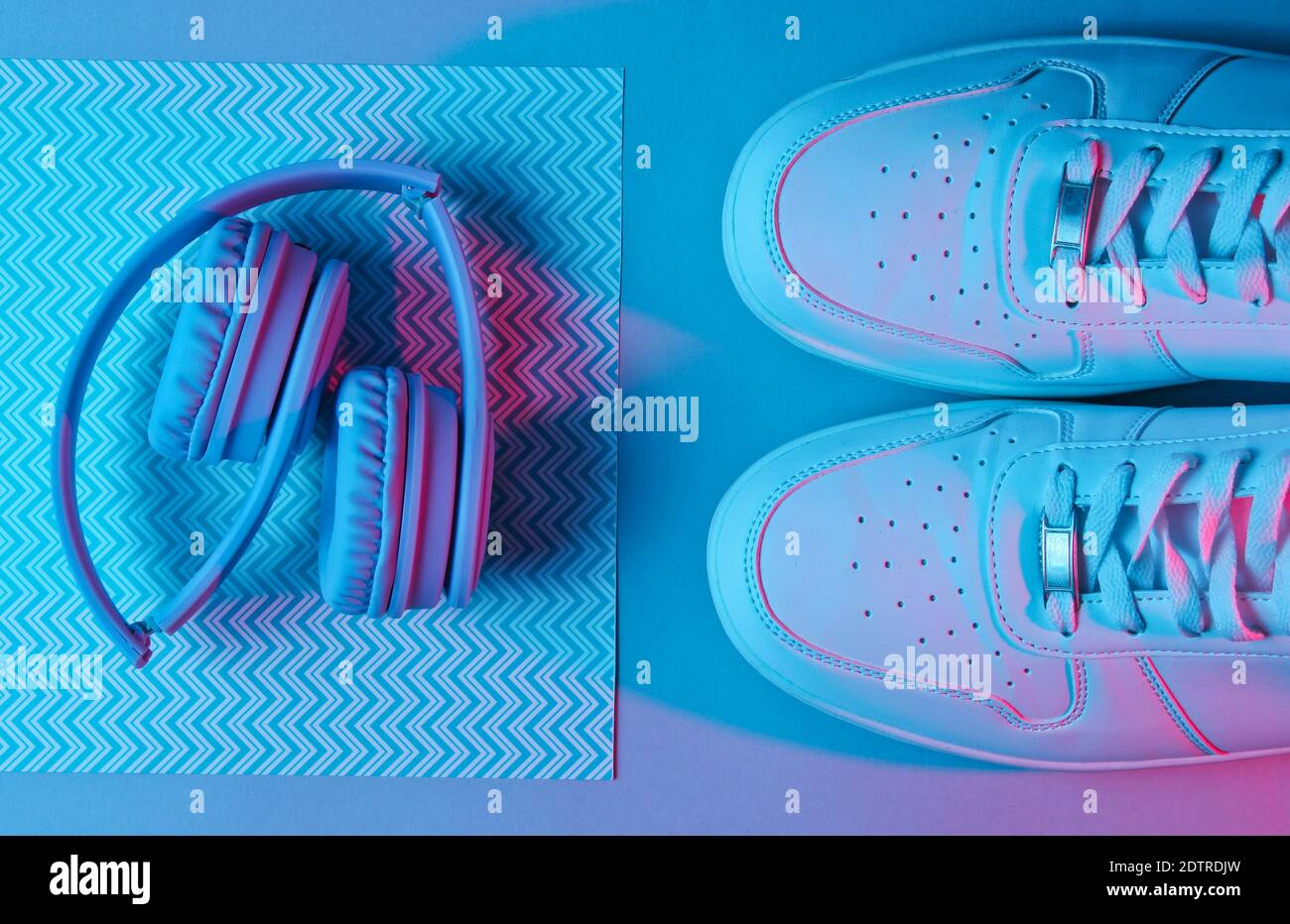 Sneakers and headphones. Retro wave, neon light, ultraviolet. Top view, minimalism Stock Photo