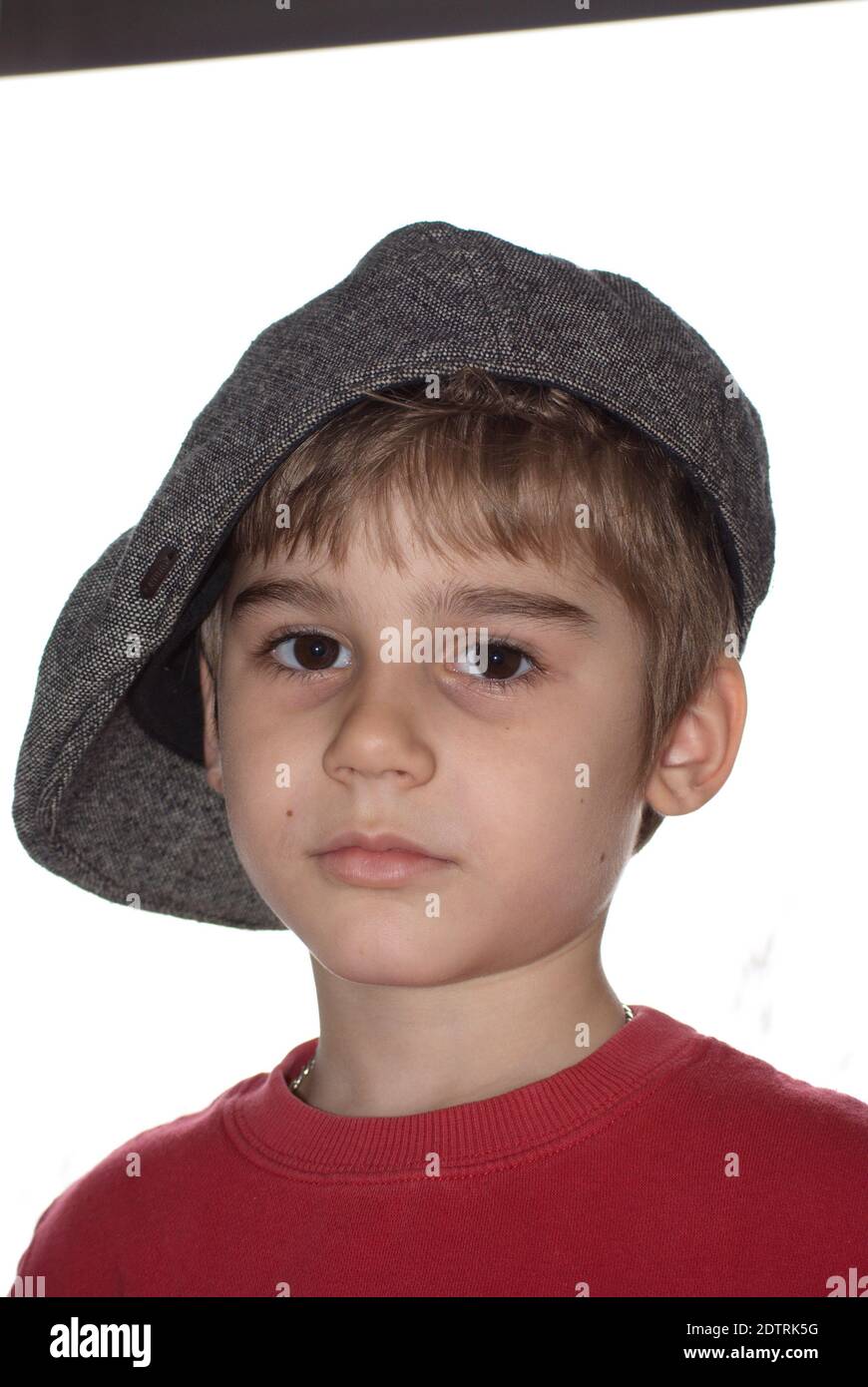 Portrait Of Boy Wearing Flat Cap Against White Background Stock Photo