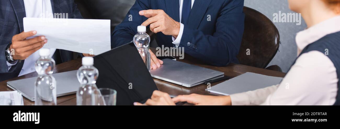 Pointing Near Businessman pointing with finger at paper while sitting near ...
