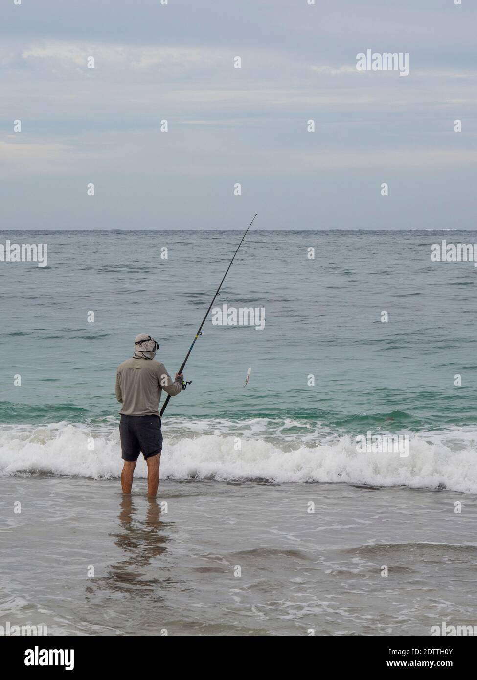 Man beach fishing with fishing rod at Guilderton Western Australia Stock Photo