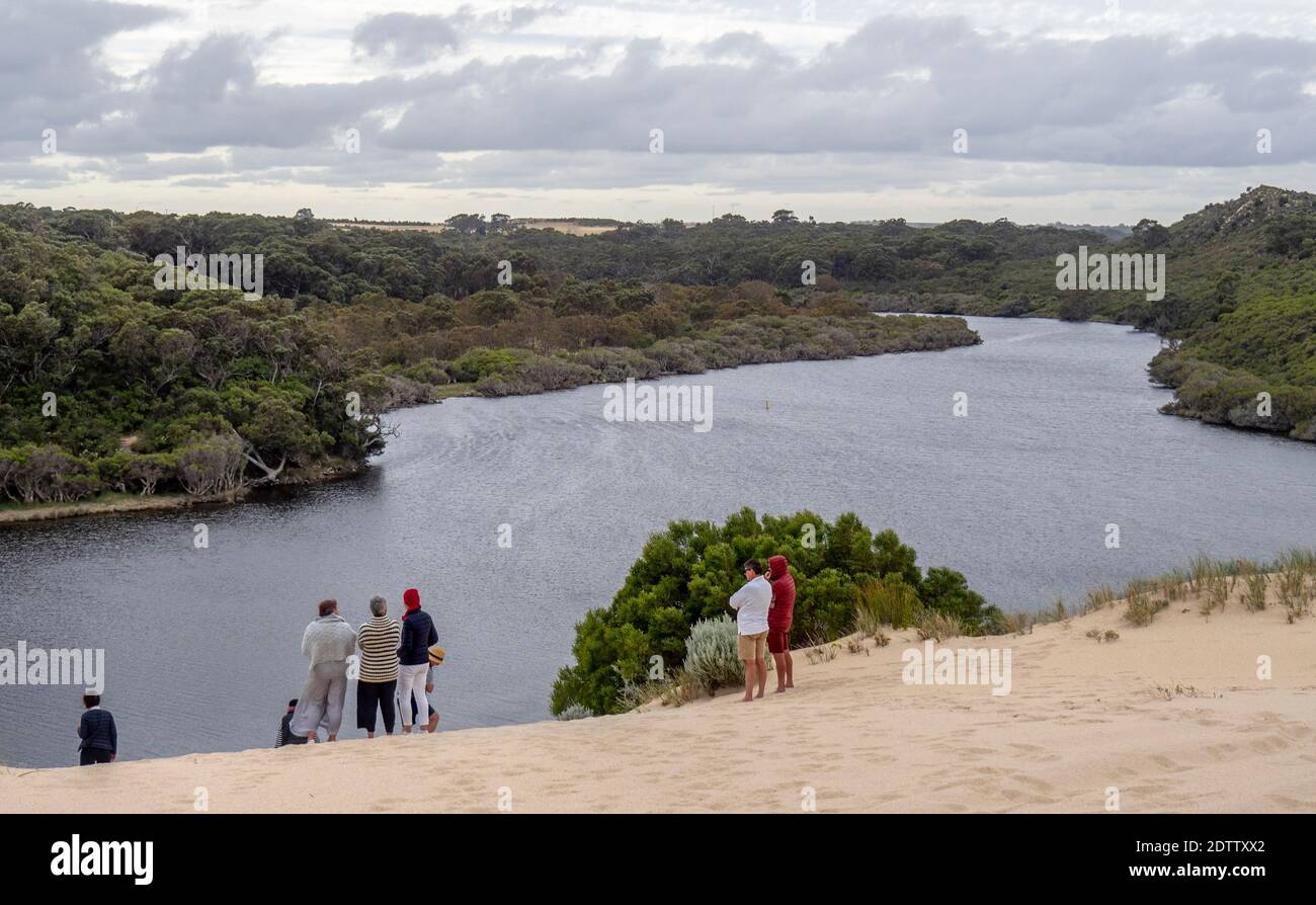Tourists standing at top of a sand dune and viewing Melaleucas and eucalyptus trees and scrubs along Moore River Guilderton Western Australia Stock Photo