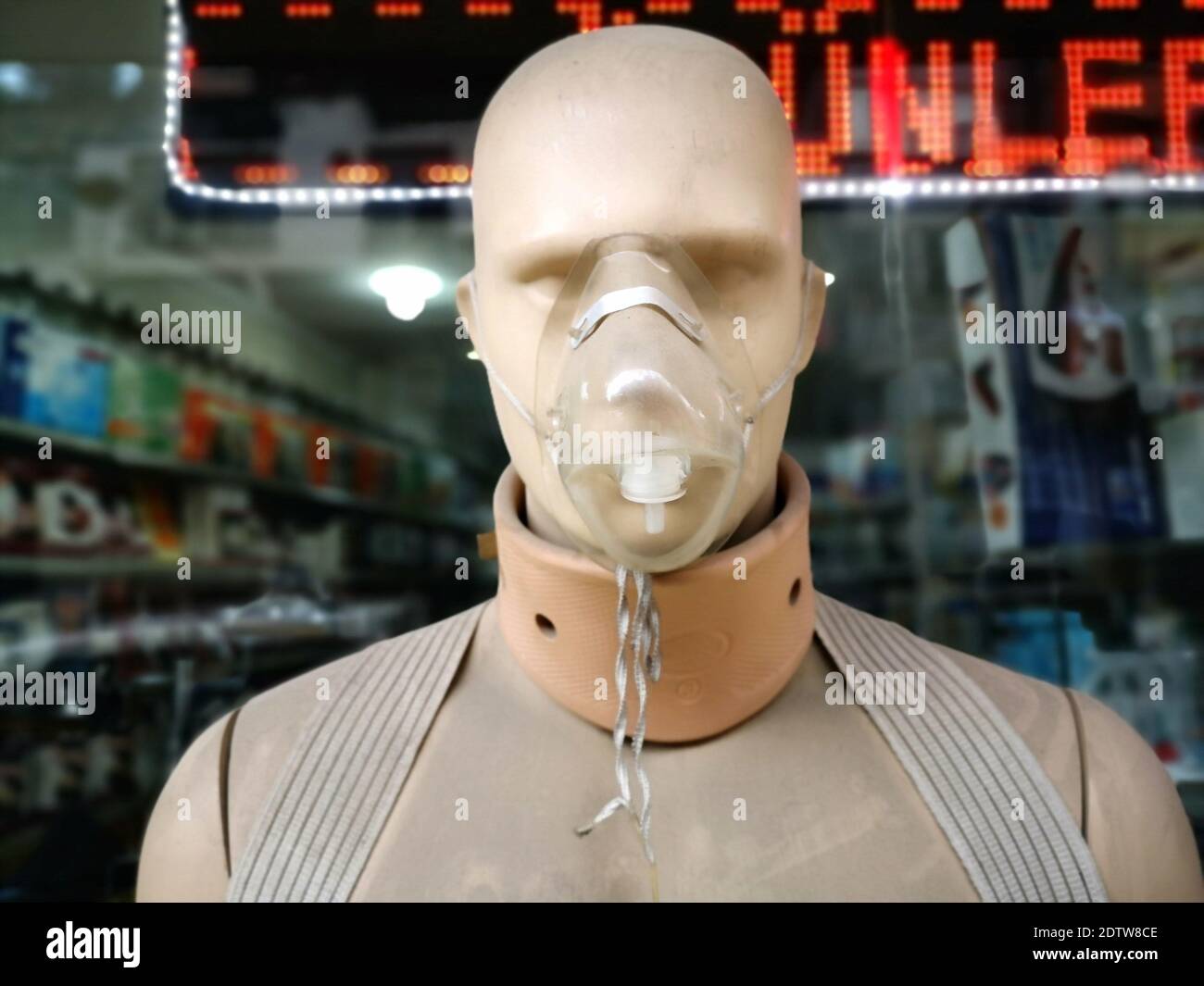 A closeup of a mannequin wearing an oxygen mask and a neck supporter in