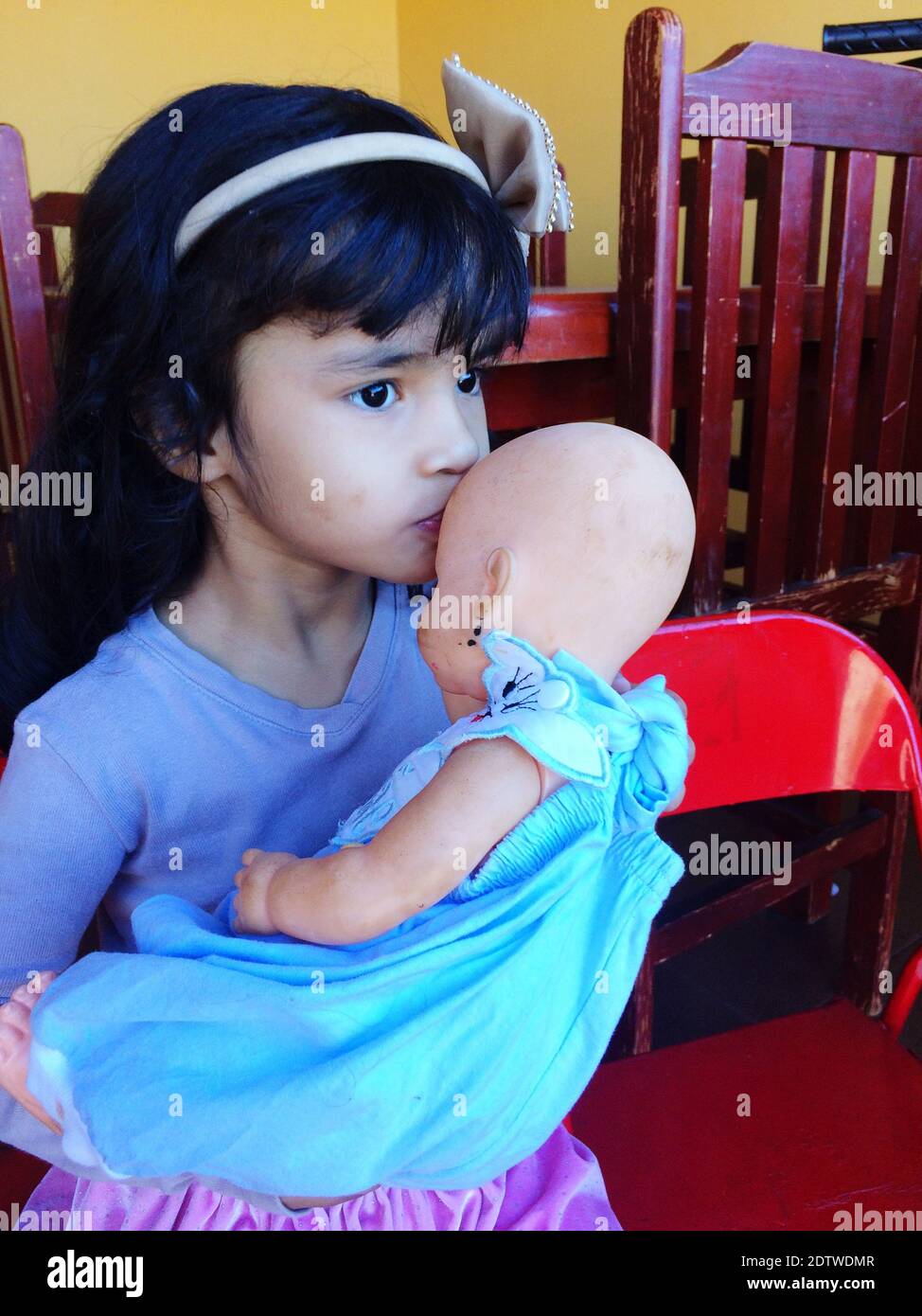 Cute Girl Kissing Doll While Standing At Home Stock Photo Alamy
