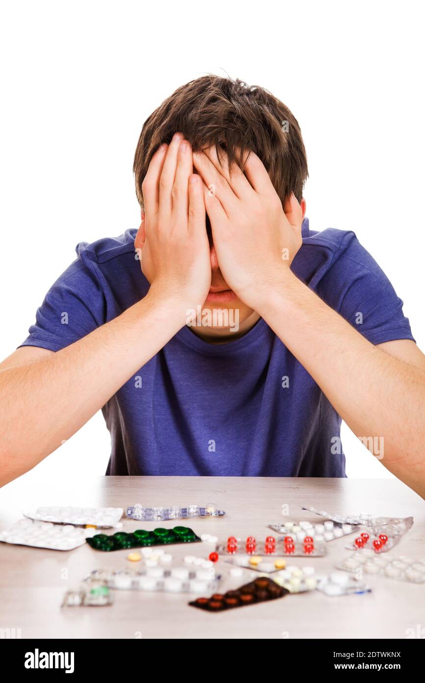 Sad Young Man with a Pills on the Table Isolated on the White Background Stock Photo