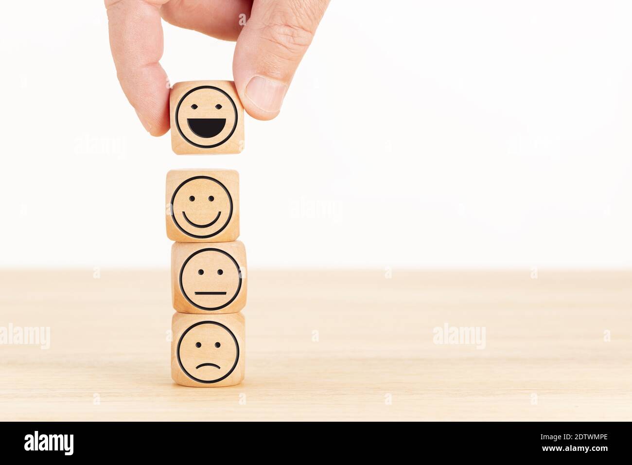 Customer service evaluation and satisfaction survey concept. Hand picked the happy face emoticon on wooden blocks. Copy space Stock Photo