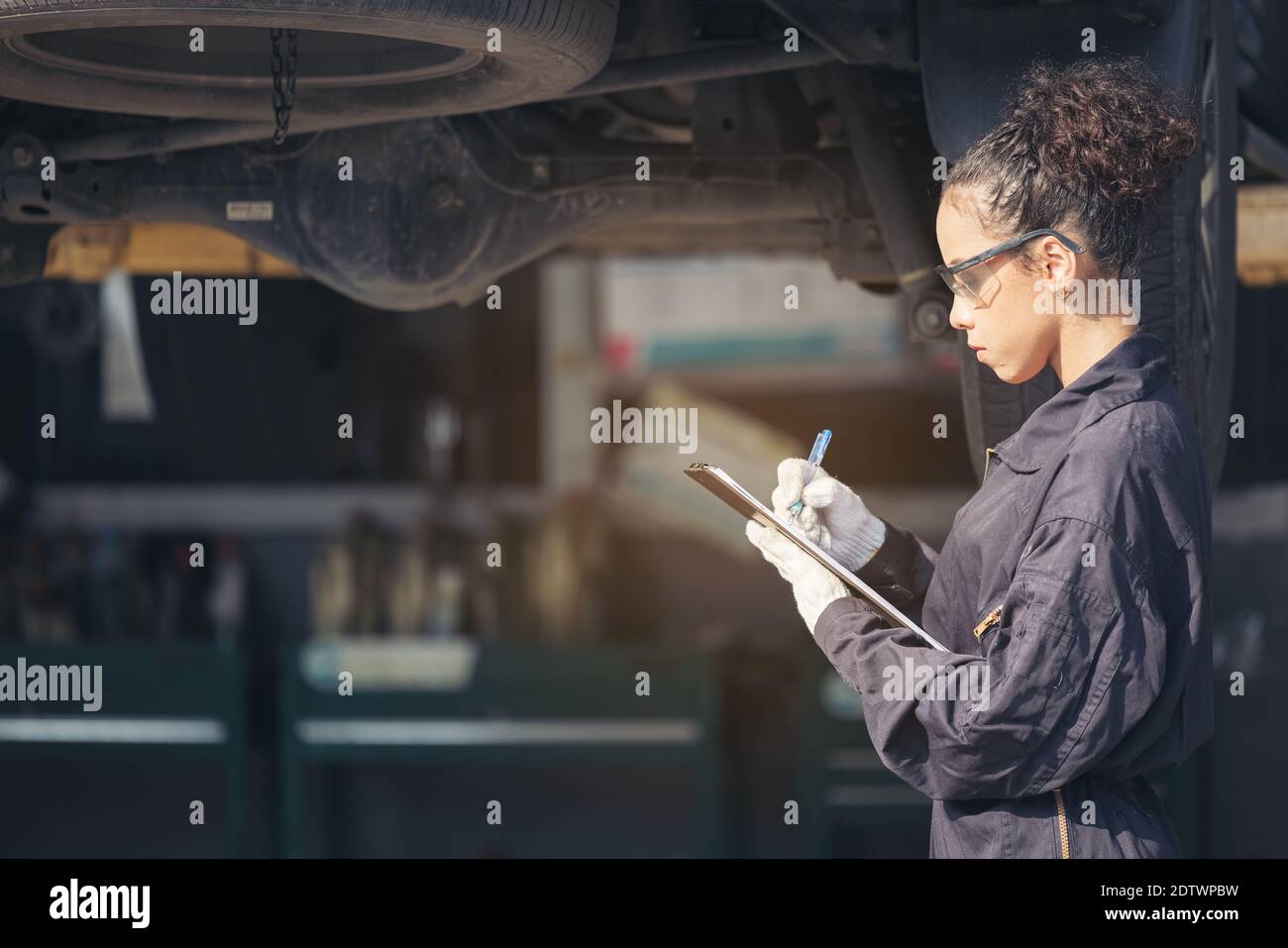 Mechanic examining underside at car service, Auto Repair Service Stock ...