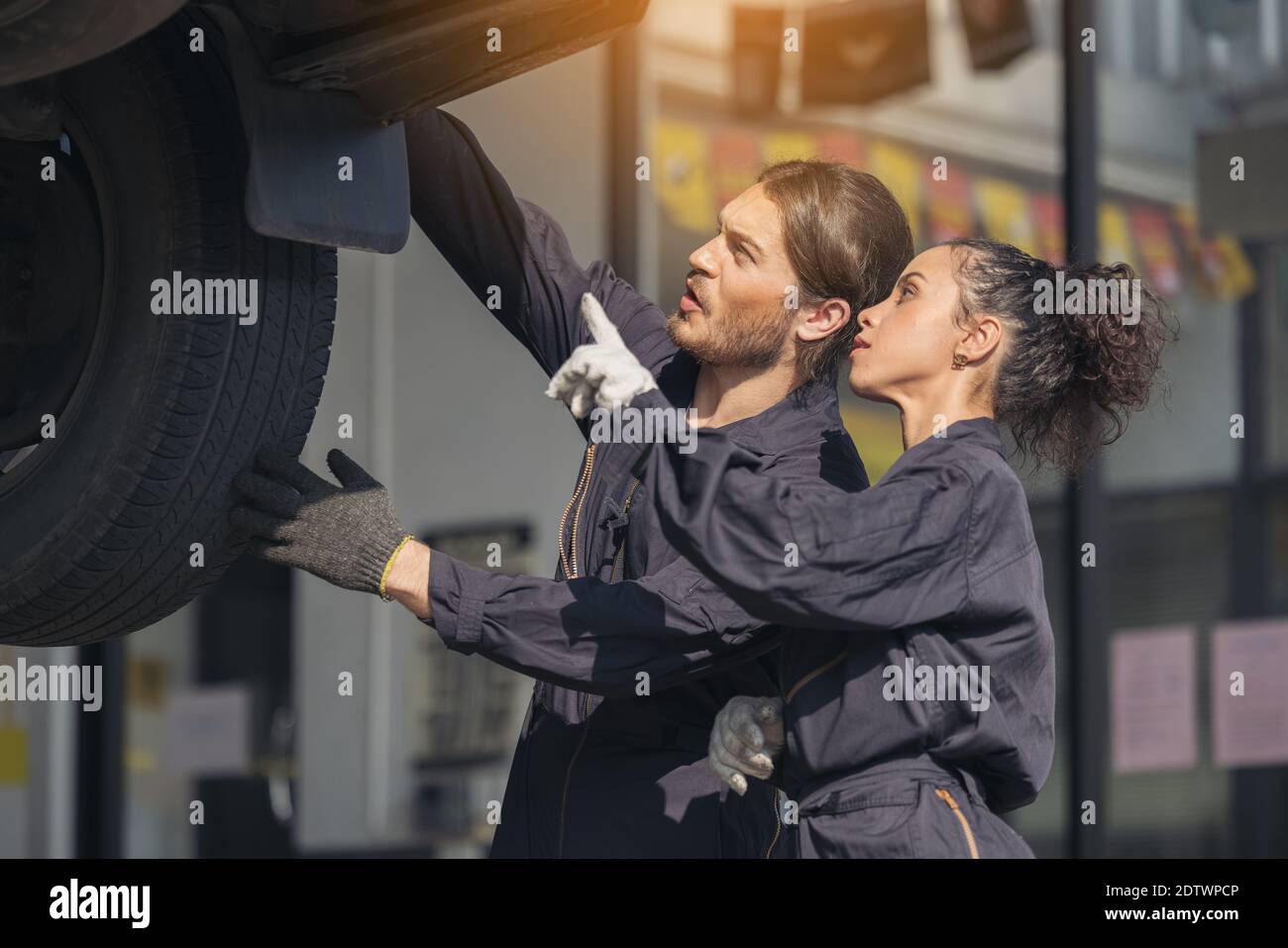 Mechanic examining underside at car service, Auto Repair Service Stock