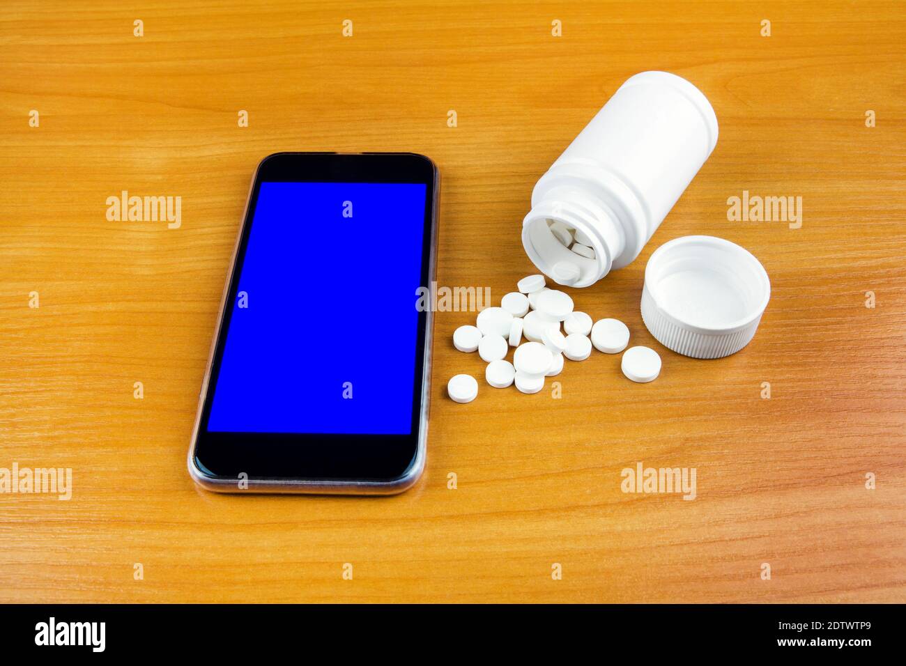 Mobile Phone with a Pills on the Wooden Table closeup Stock Photo