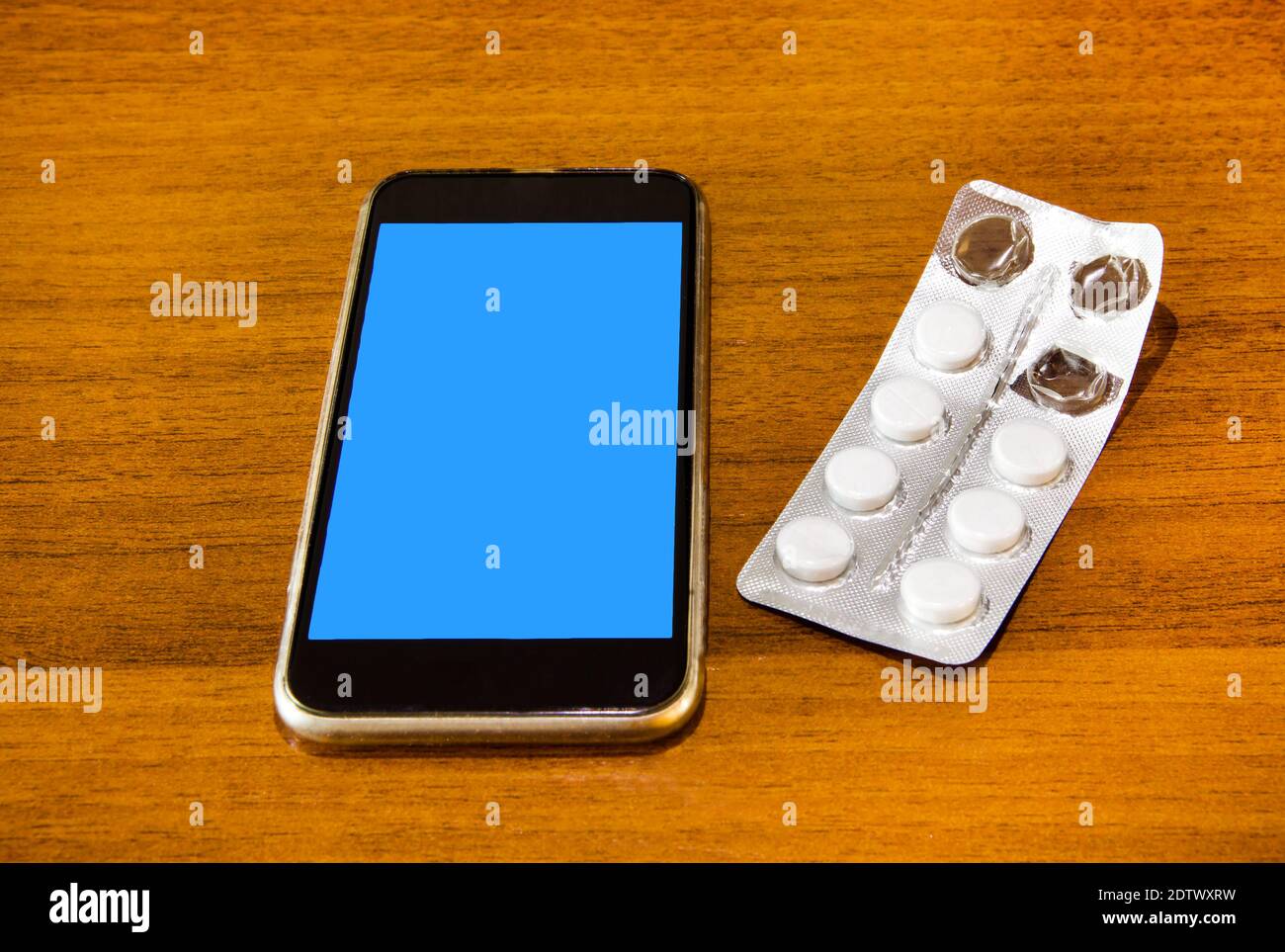 Mobile Phone with a Pills on the Wooden Table closeup Stock Photo