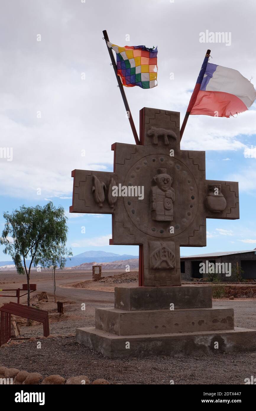 La Wiphala, representing the many Andean peoples,  flies beside the Chilean flag from the Inca cross at the entrance to the Valle de la Luna. Stock Photo