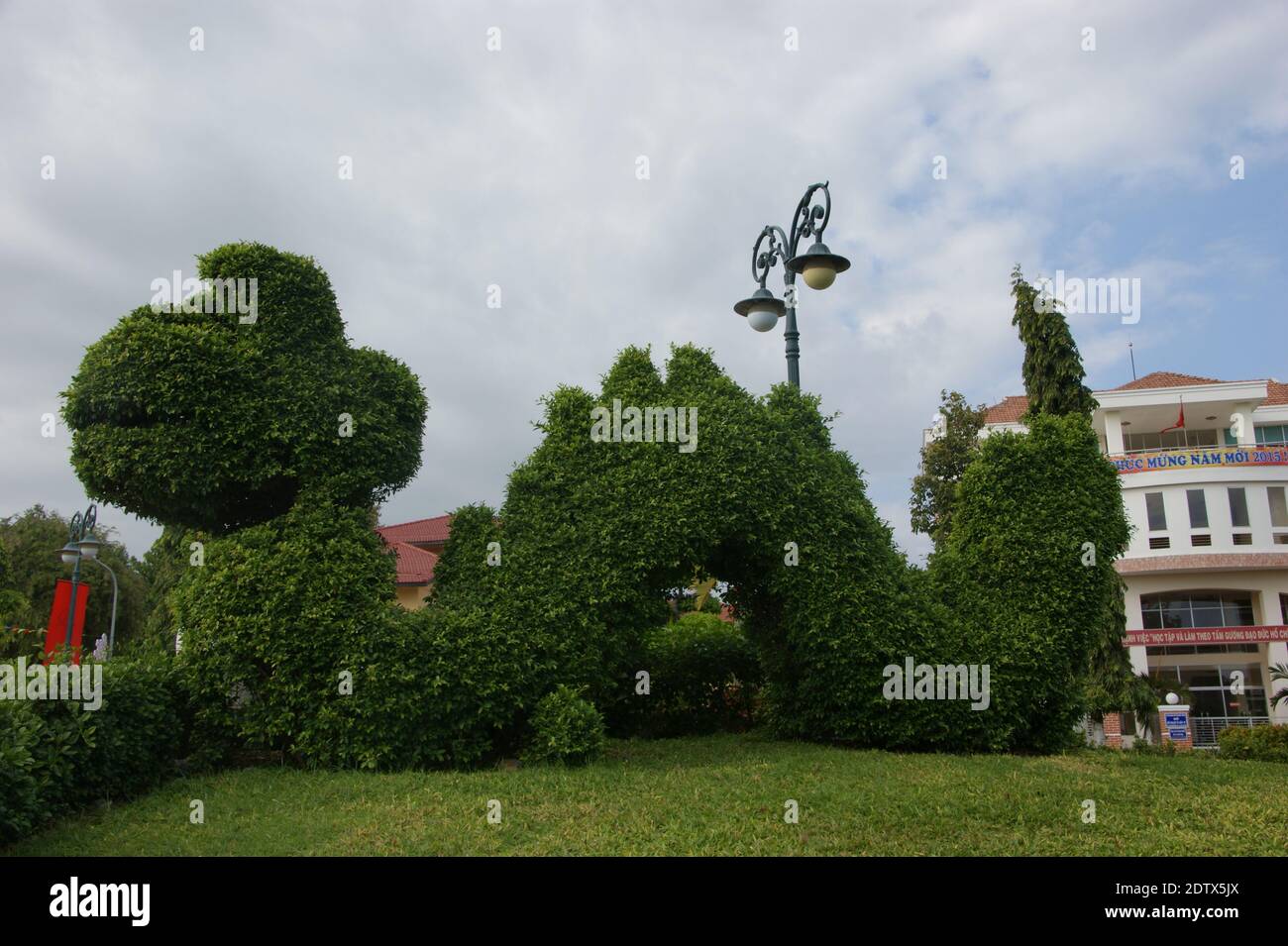 Green dragon clipped in a large arborisculpture in a Vietnamese park, Stock Photo
