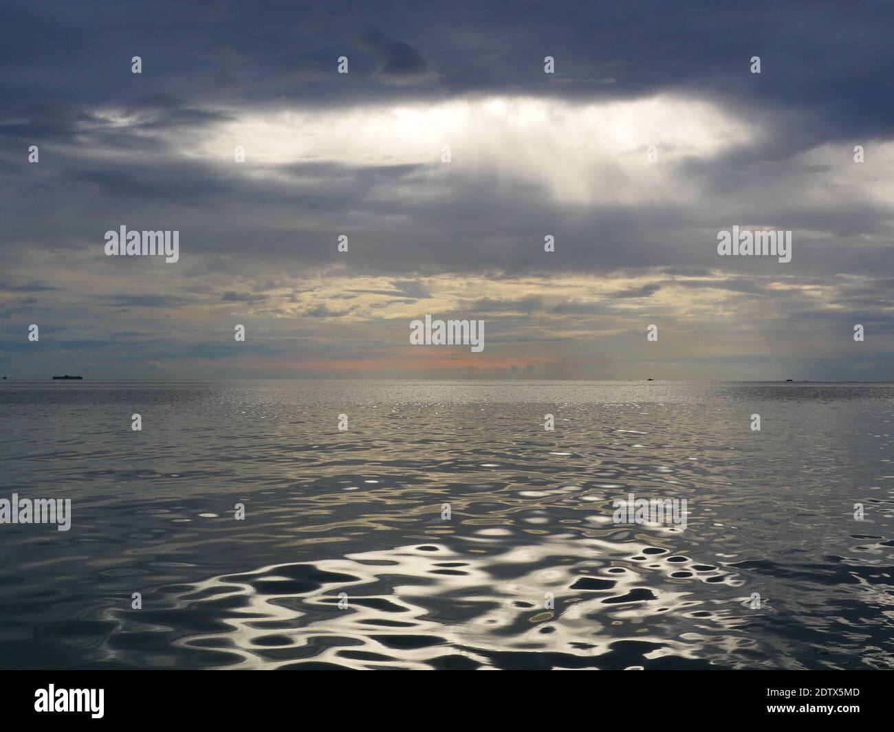 sea dramatic landscape with rays through a cloudy dark sky Stock Photo