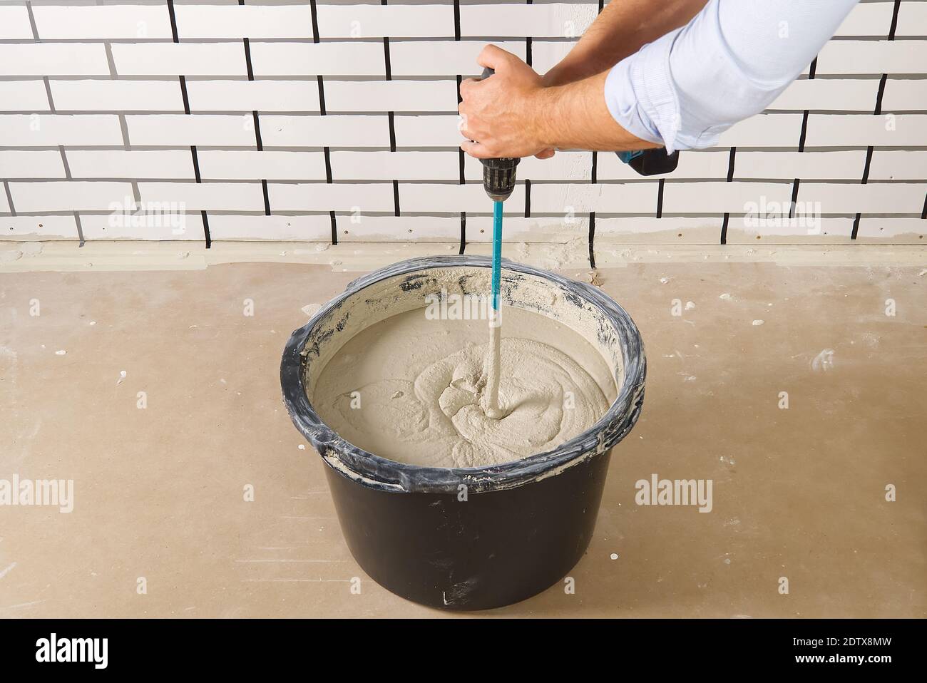 the master mixes the plaster in a bucket. Flat house renovation, master