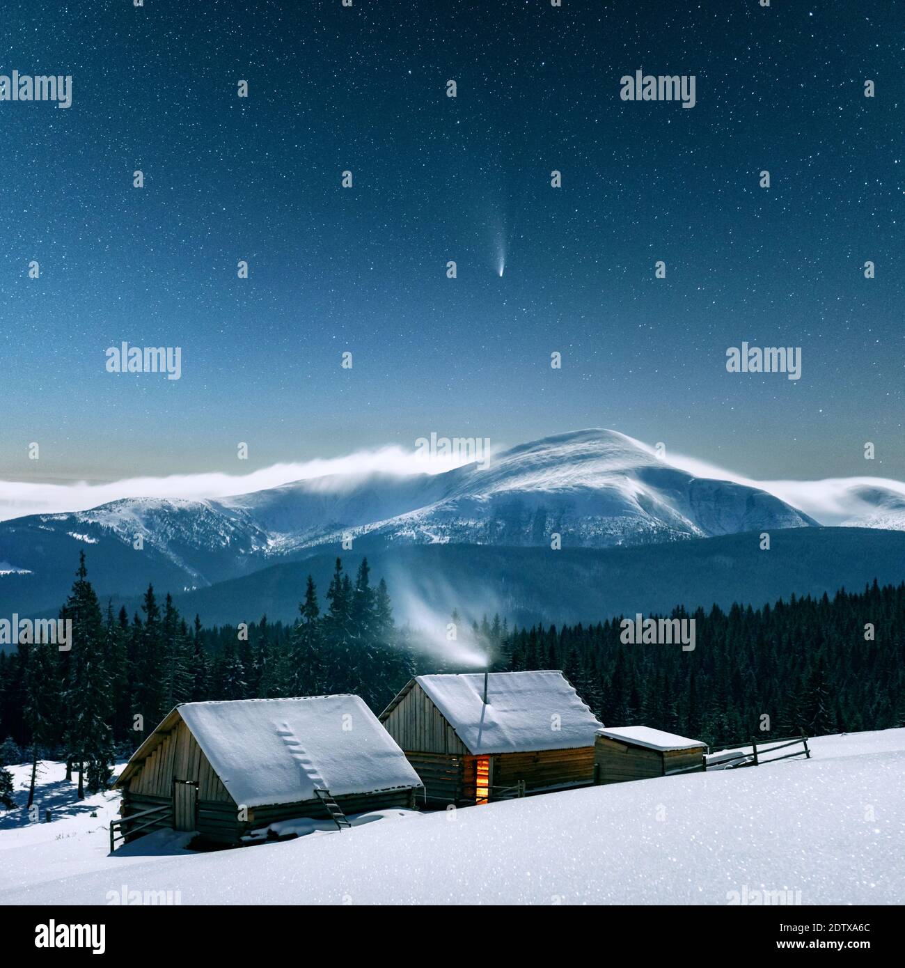 Fantastic winter landscape with wooden house in snowy mountains. Starry sky with Milky Way and snow covered hut. Christmas holiday and winter vacations concept Stock Photo