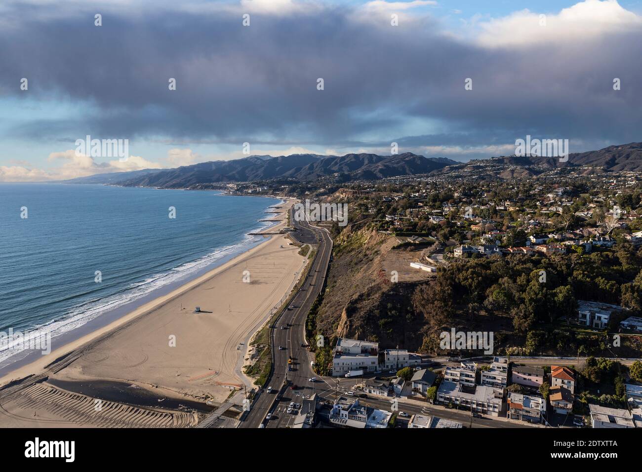 Aerial view of homes, beaches, mountains with stormy sky in the Pacific Palisades area of Los