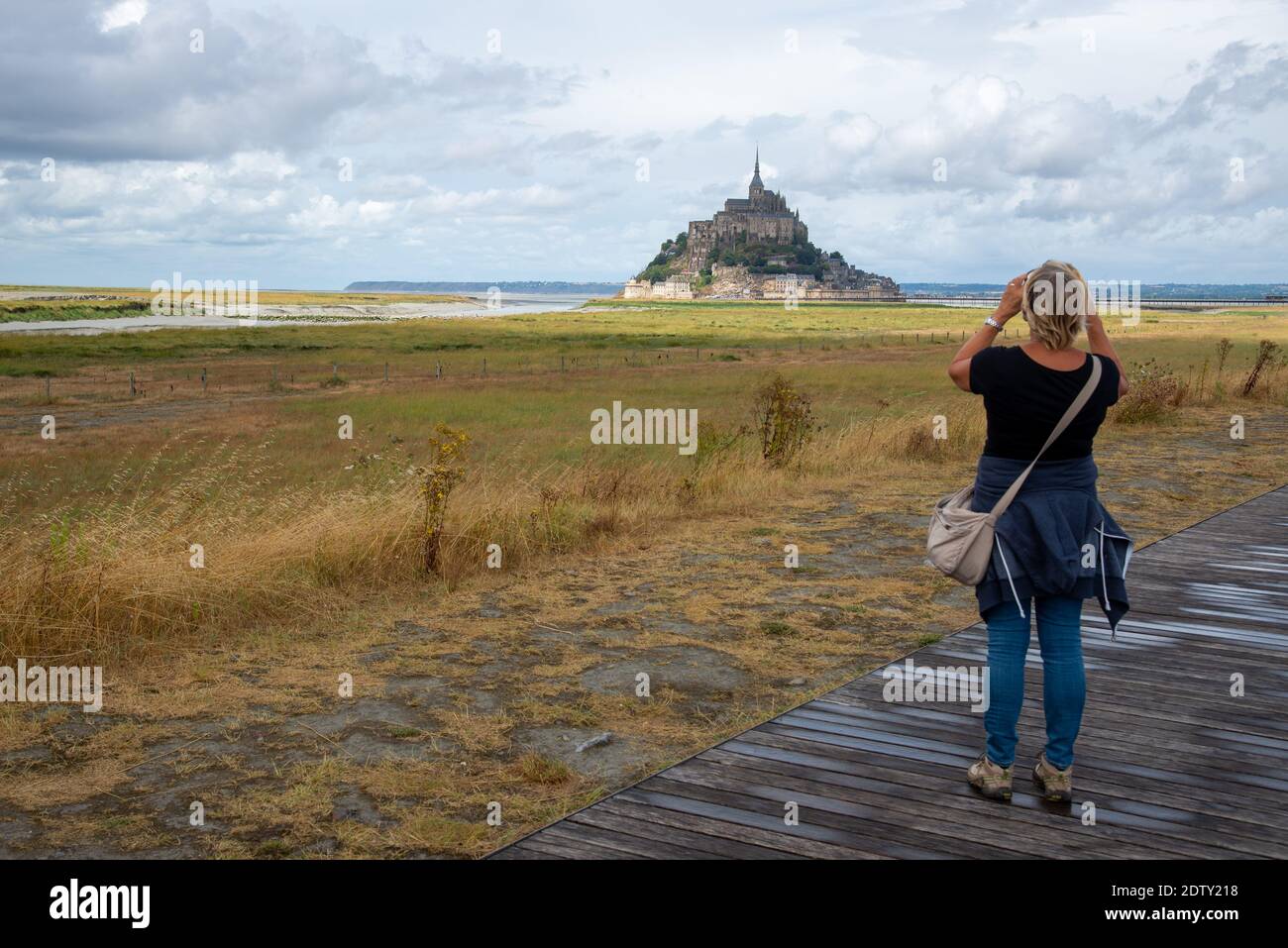 woman taking picture of Mont St. Michel in Bretagne, France Stock Photo
