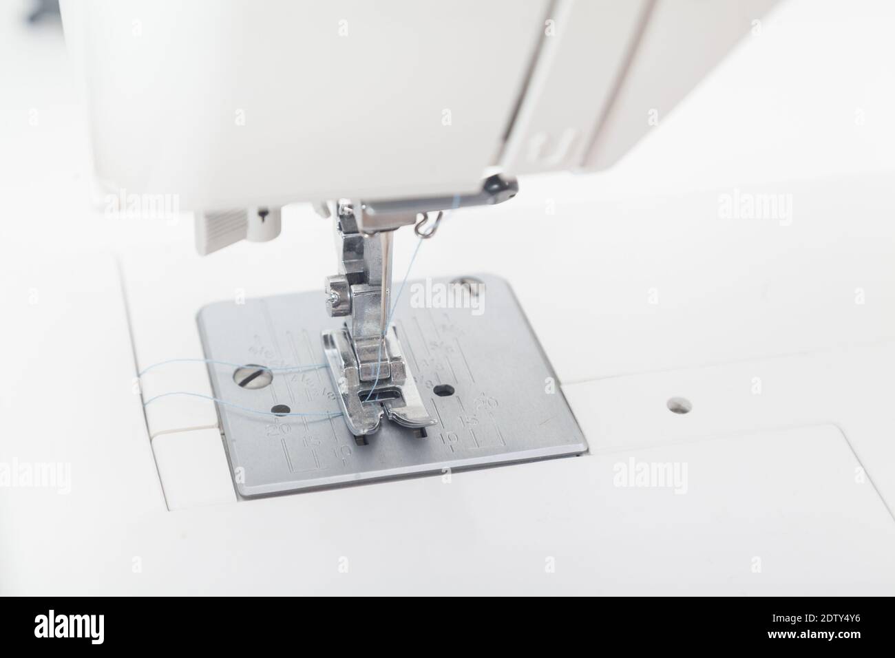 sewing machine needle against white background Stock Photo - Alamy