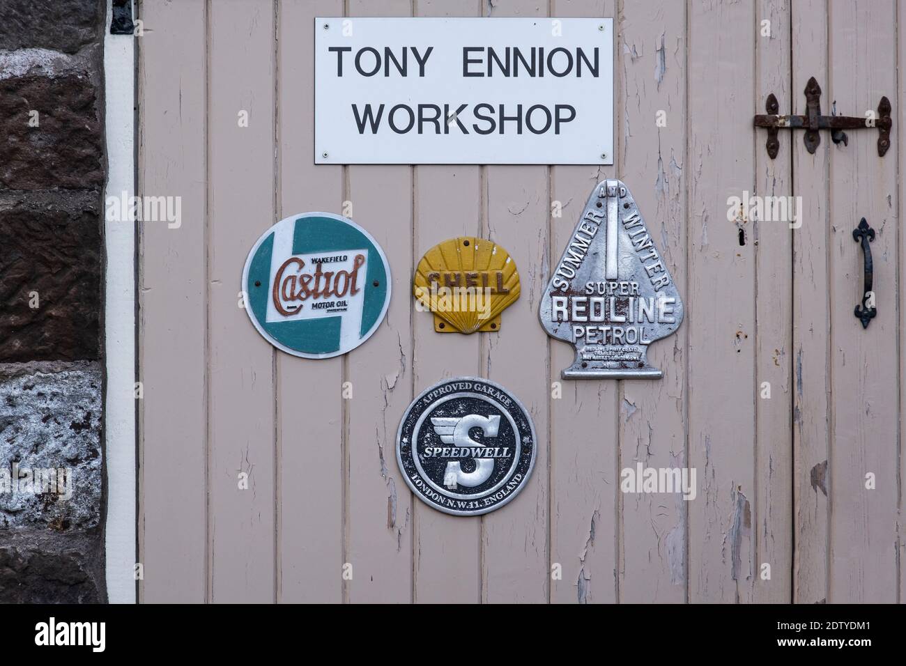 Old Motor Industry Badges on Garage Door, Peckforton, Cheshire, England, UK Stock Photo