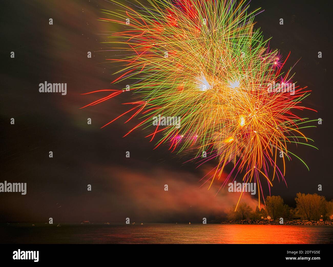 Fireworks at night over a surface of water Stock Photo