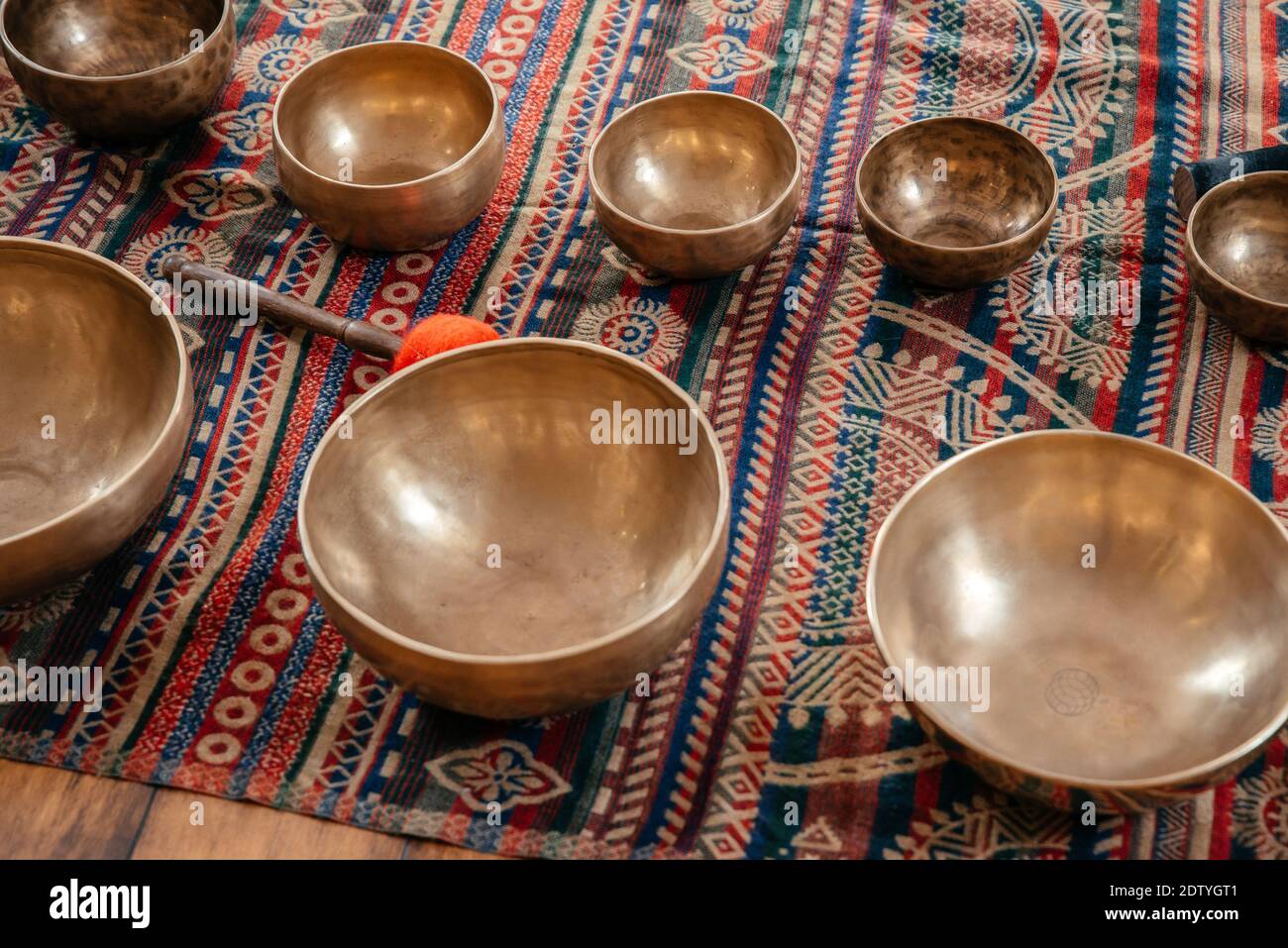 Tibetan handcrafted singing bowls on the floor in yoga class, sound therapy concept Stock Photo