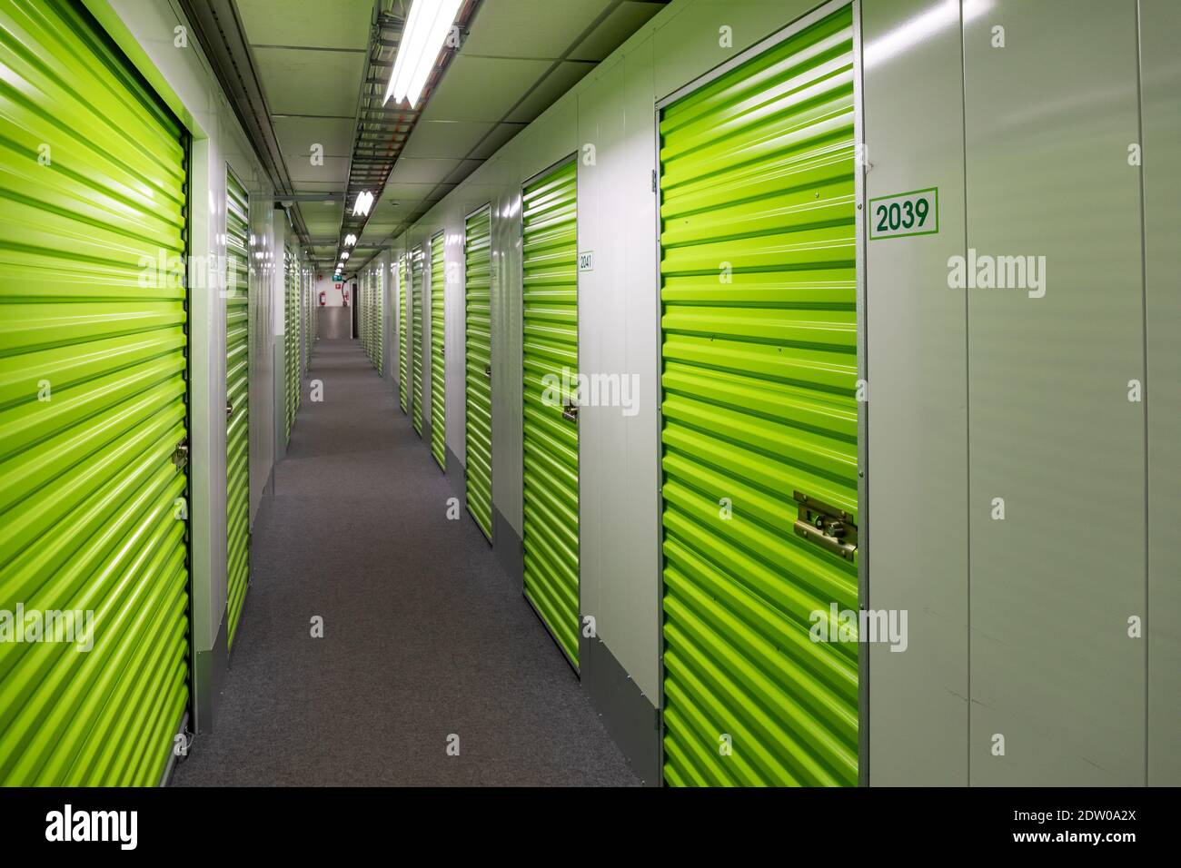Self-storage corridor with green doors Stock Photo