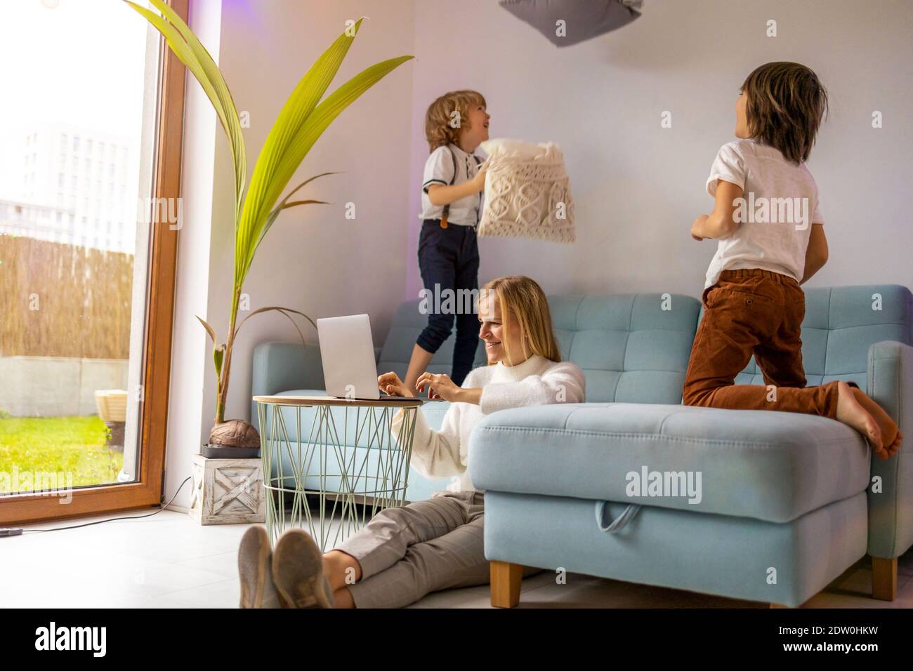 Mother trying to work from home with her kids as a company Stock Photo