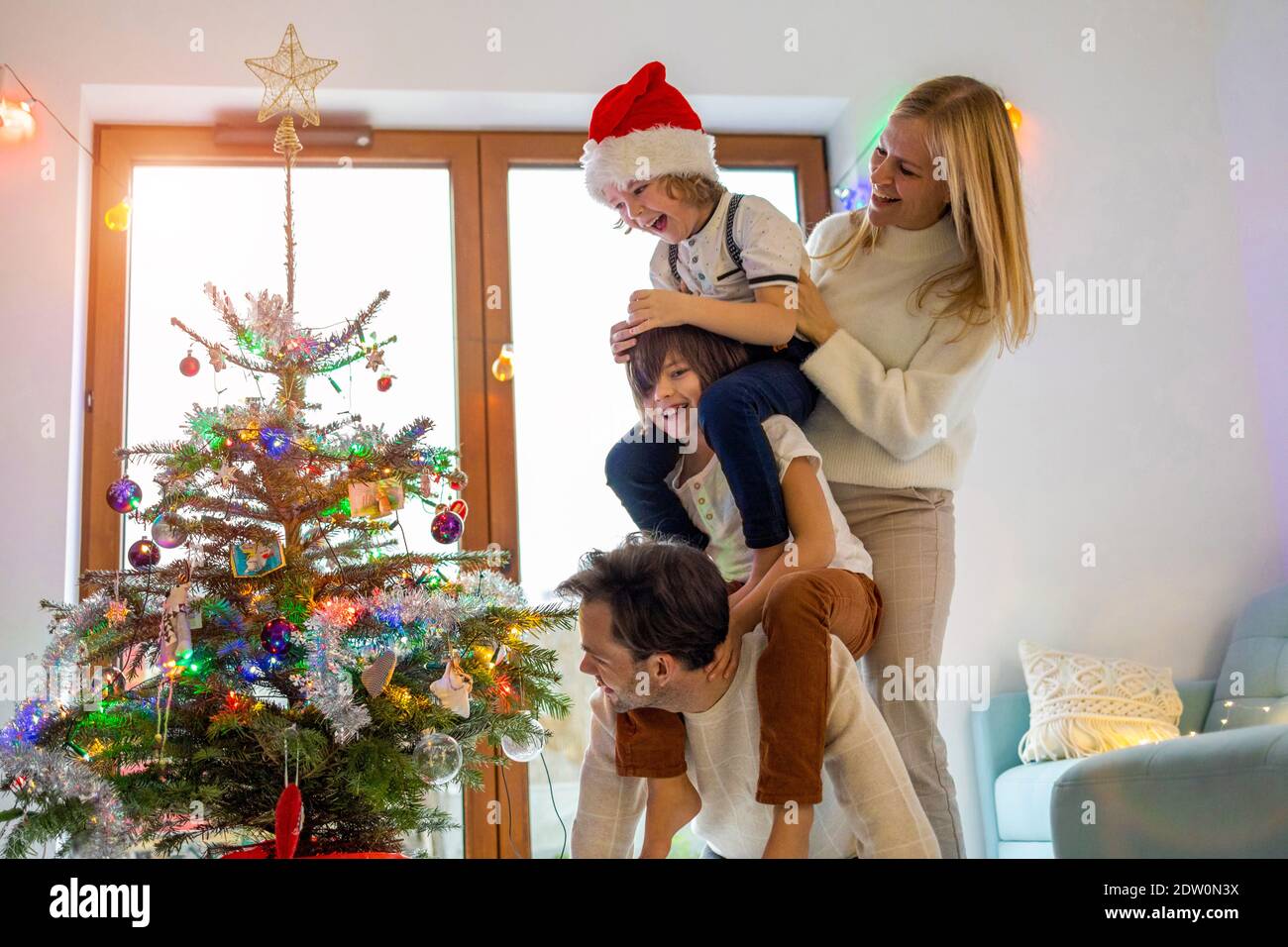 Young family having fun decorating Christmas tree Stock Photo