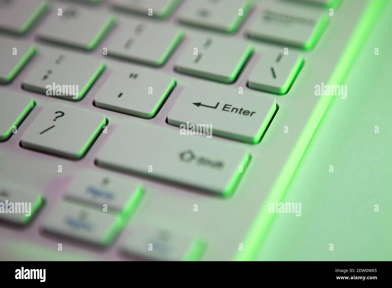 Close up detail of a Green highlighted enter key on a computer keyboard Stock Photo