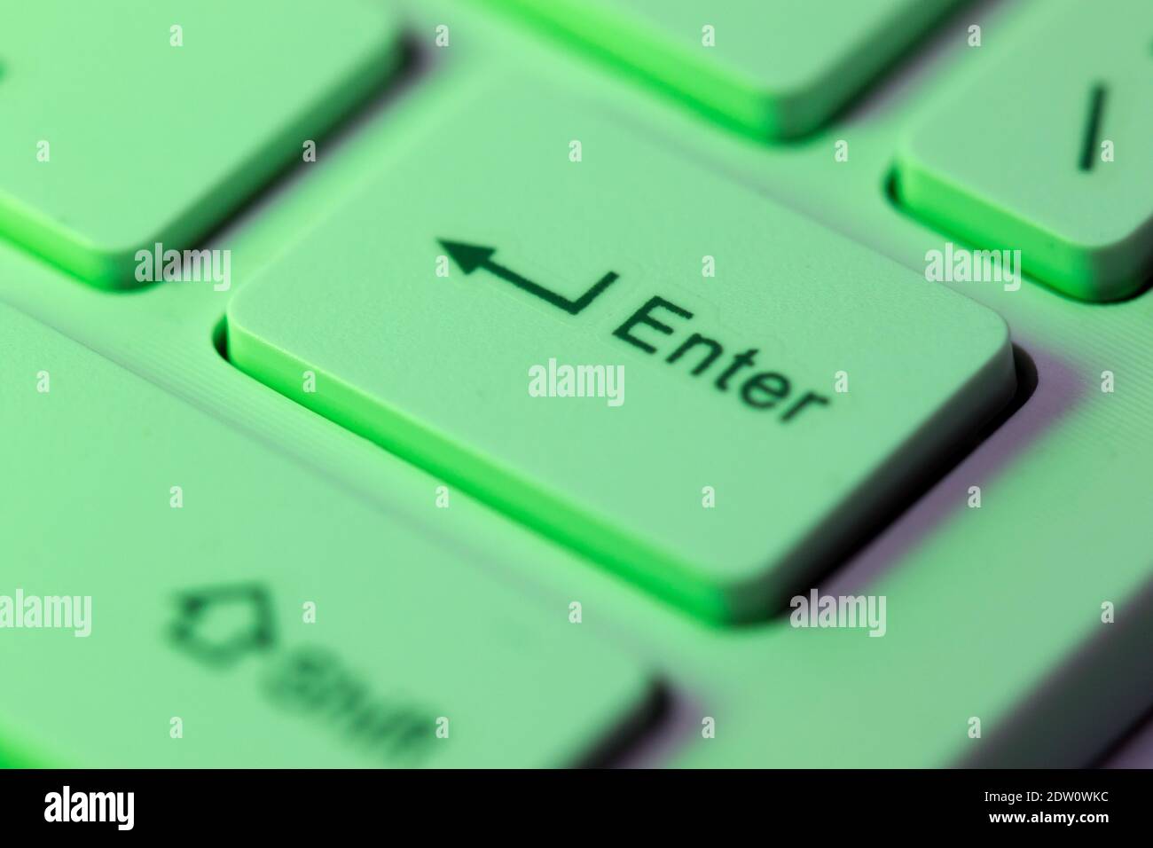 Close up detail of a Green highlighted enter key on a computer keyboard Stock Photo