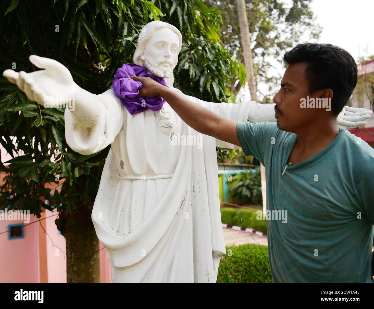 A worker cleaning a statue of Jesus Christ at a church in preparation
