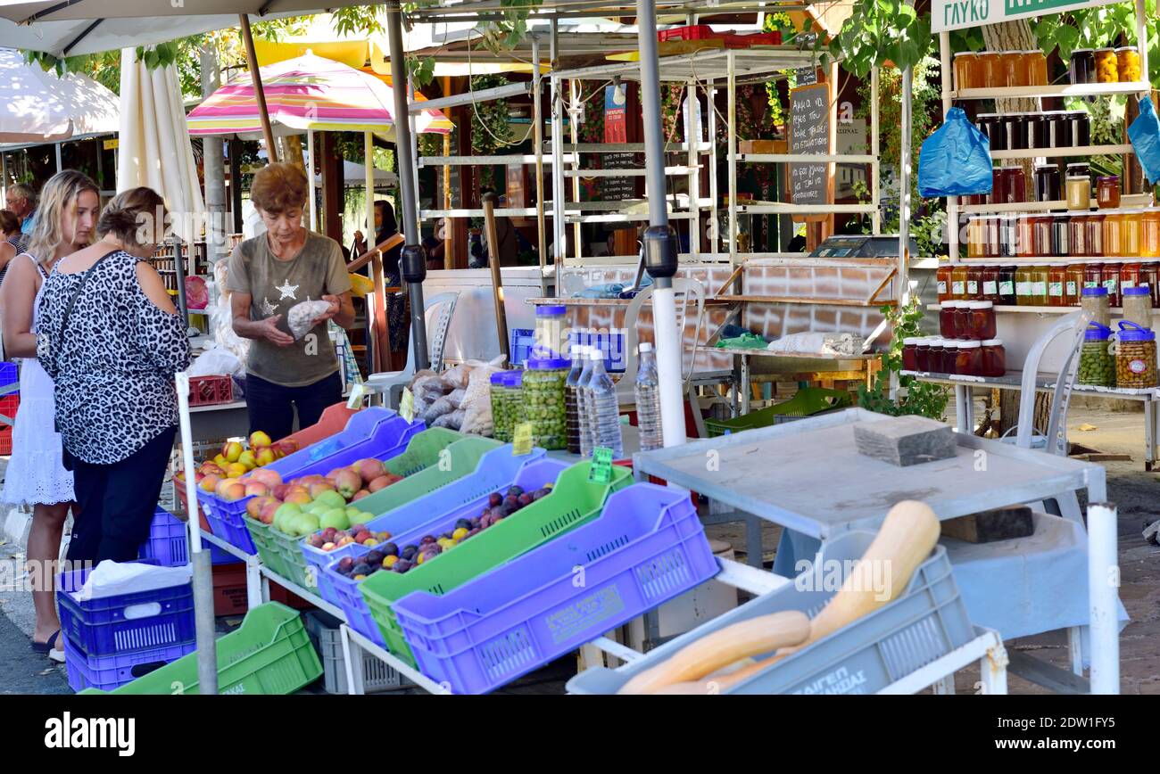 Fruit, bottled preserves along with shopper by roadside market stall in Trimiklini village near Limassol, Cyprus Stock Photo