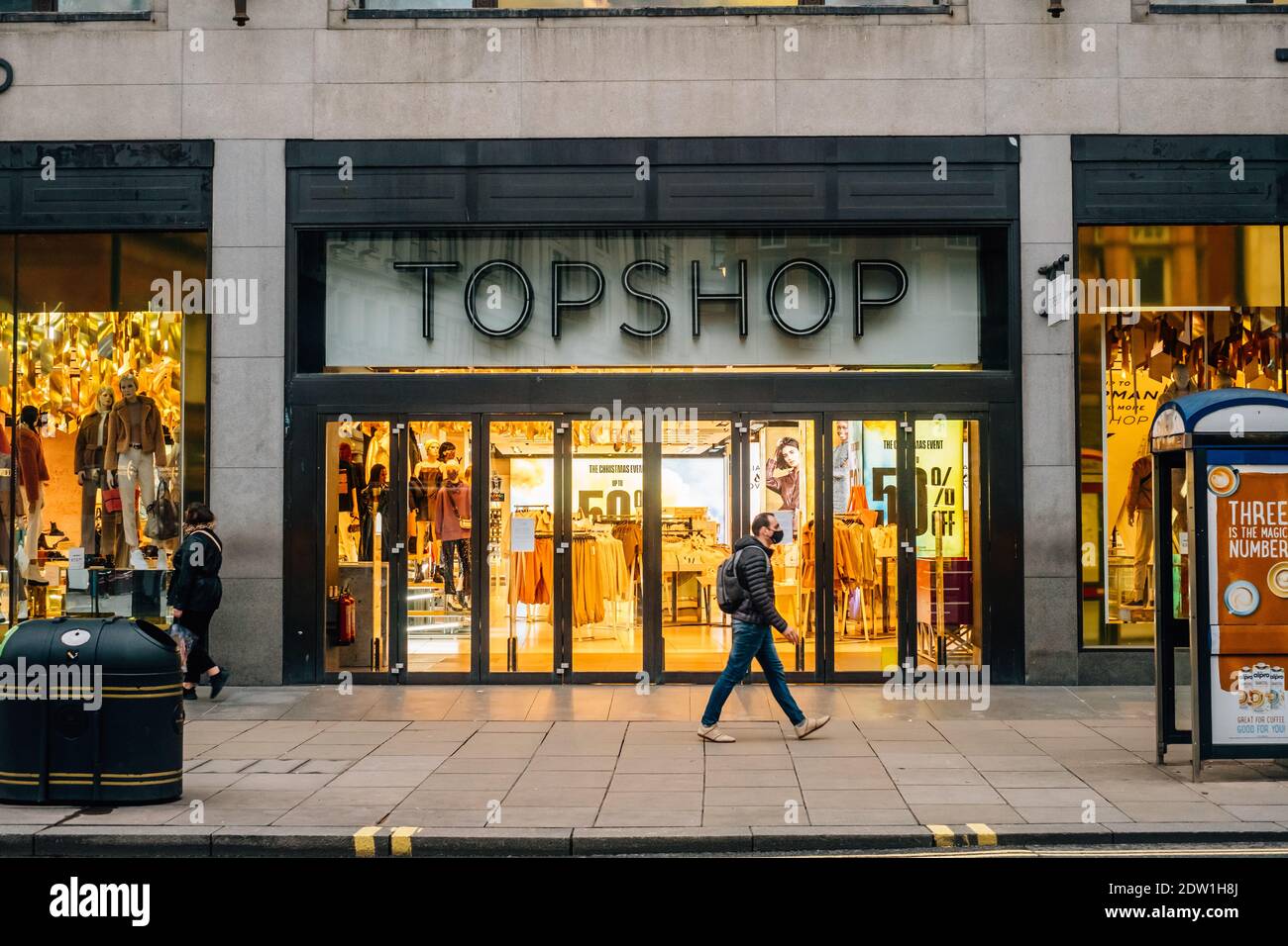 Oxford Street, London, UK. 22nd December 2020. A man in a facemask walks  past Topshop which is closed due to Tier 4 restrictions. With most shops in  central London closed, Oxford Street