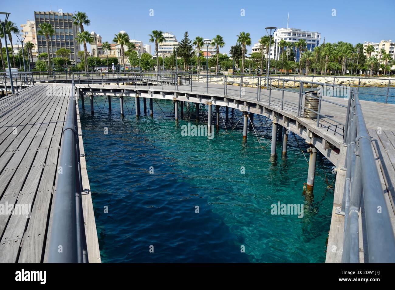 Blue clear water of the Mediterranean sea seen from Moles beach pier with city of Limassol, Cyprus Stock Photo