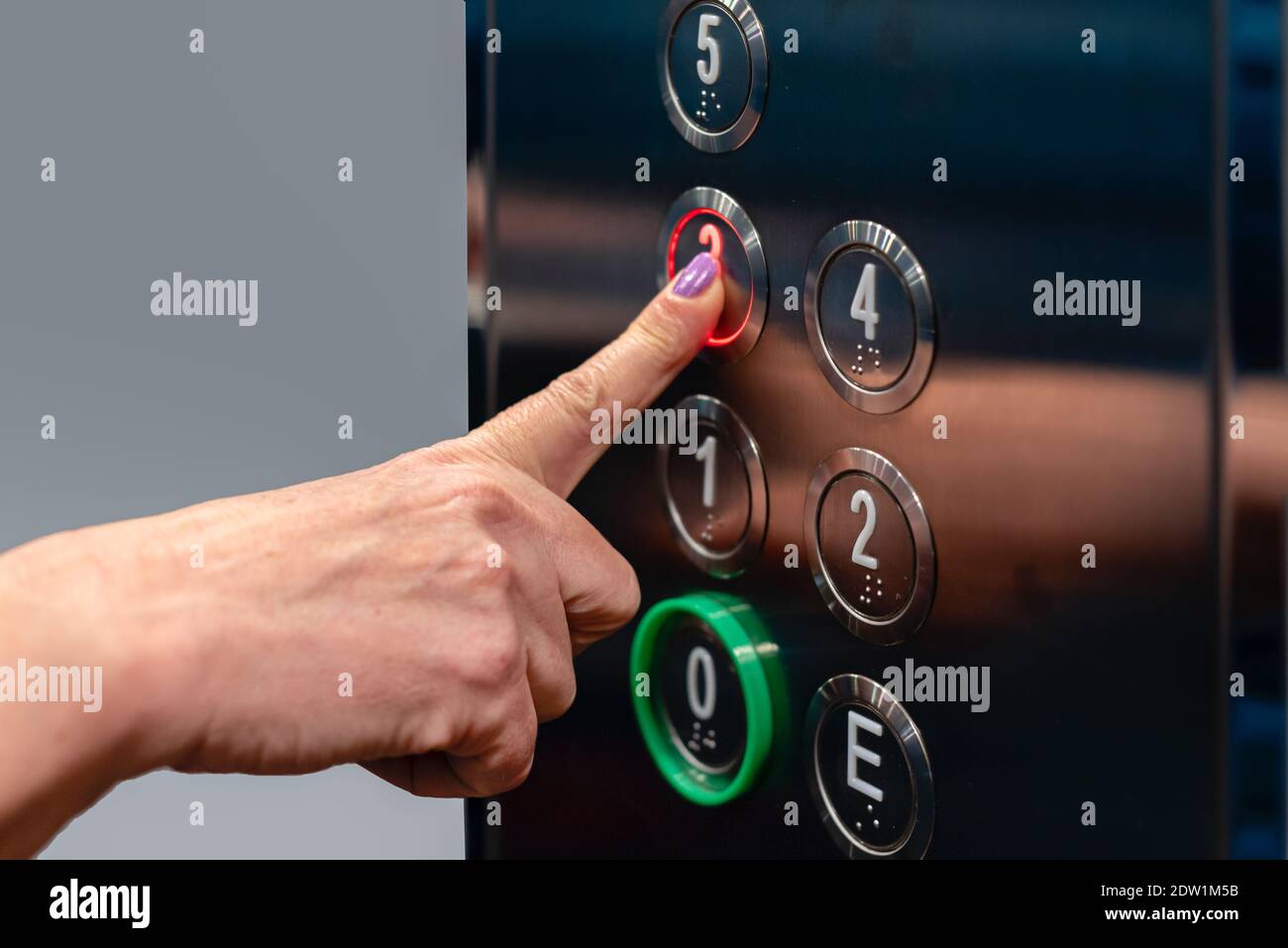 Finger pressing elevator button Stock Photo