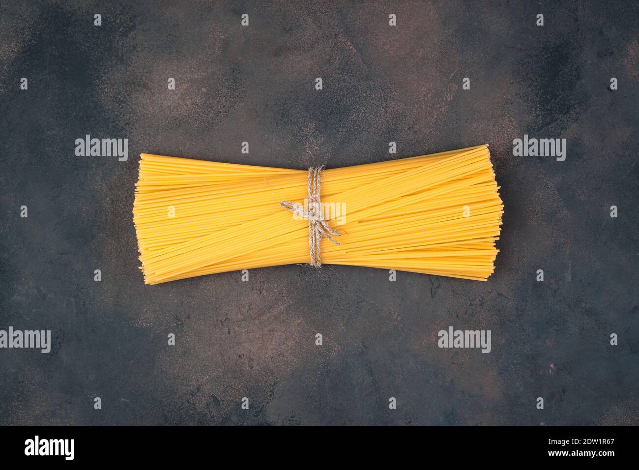 Long Spaghetti tied with thread on a brown concrete background Stock ...