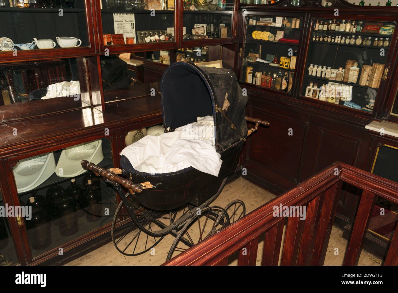 Vintage antique baby stroller with blankets, inside of the drugstore building Stock Photo