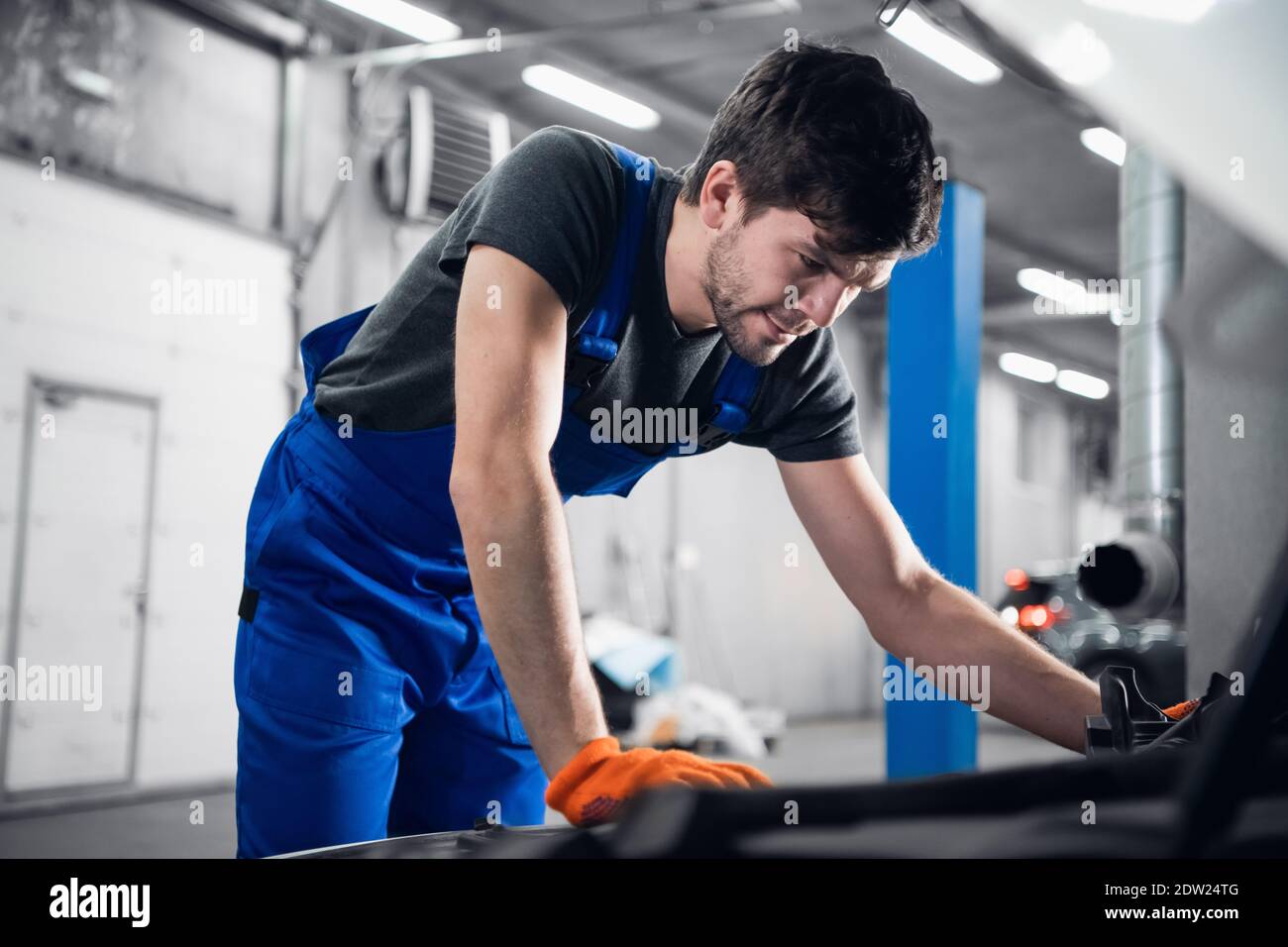 Repairer opened the hood of the car and checks the engine Stock Photo ...