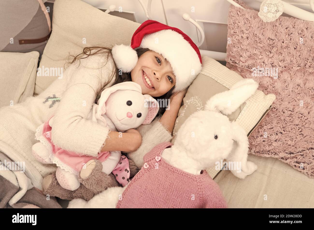 Drifting off to sleep. Sleepy baby in bed. Tired child cuddle toys in bed. Bedtime routine. Got ready for bed. Christmas eve good night. Rest warm and cosy in your bed. Sleep well. Stock Photo