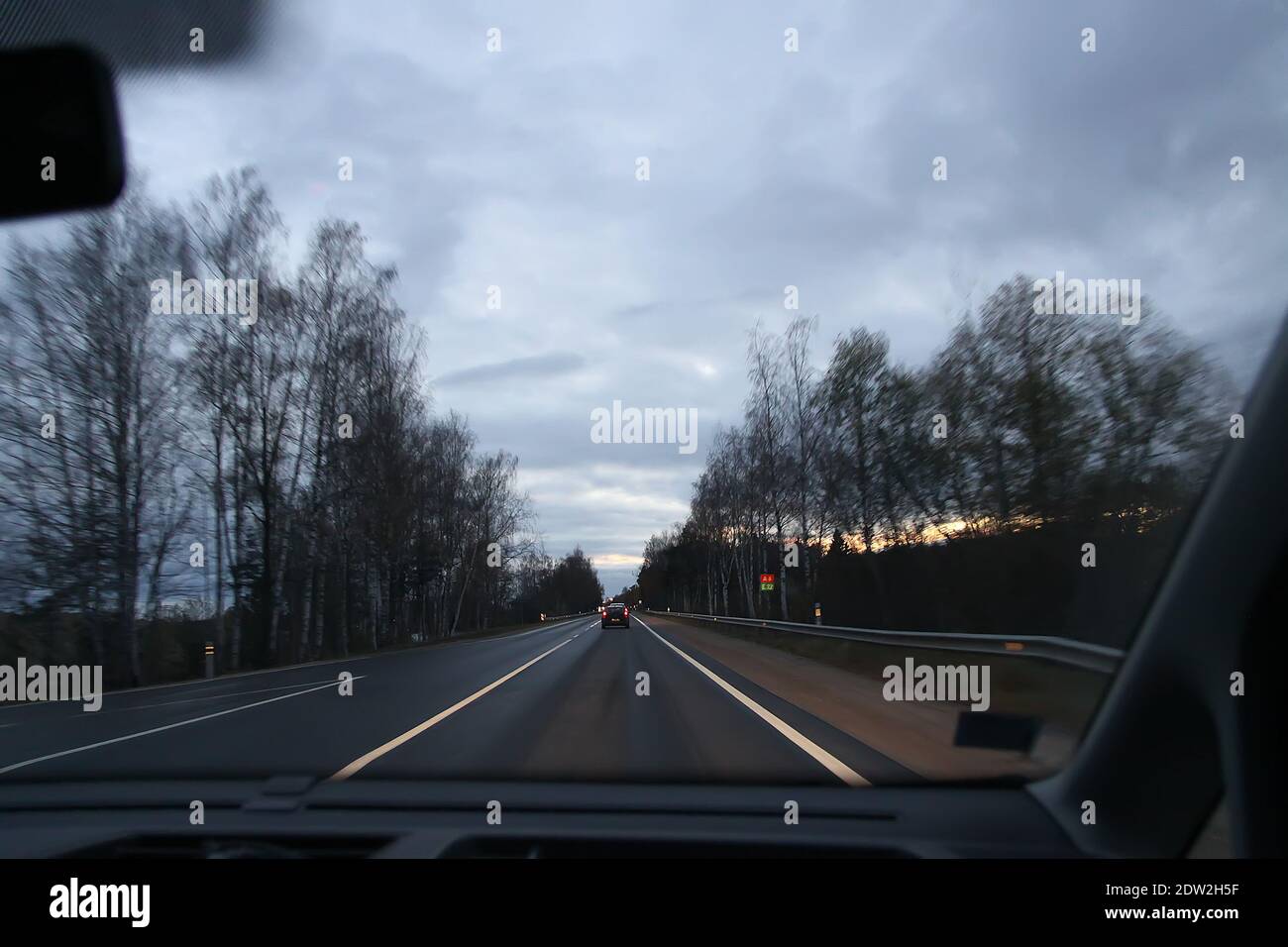 View through the moving car windscreen inside the car interior. Stock Photo