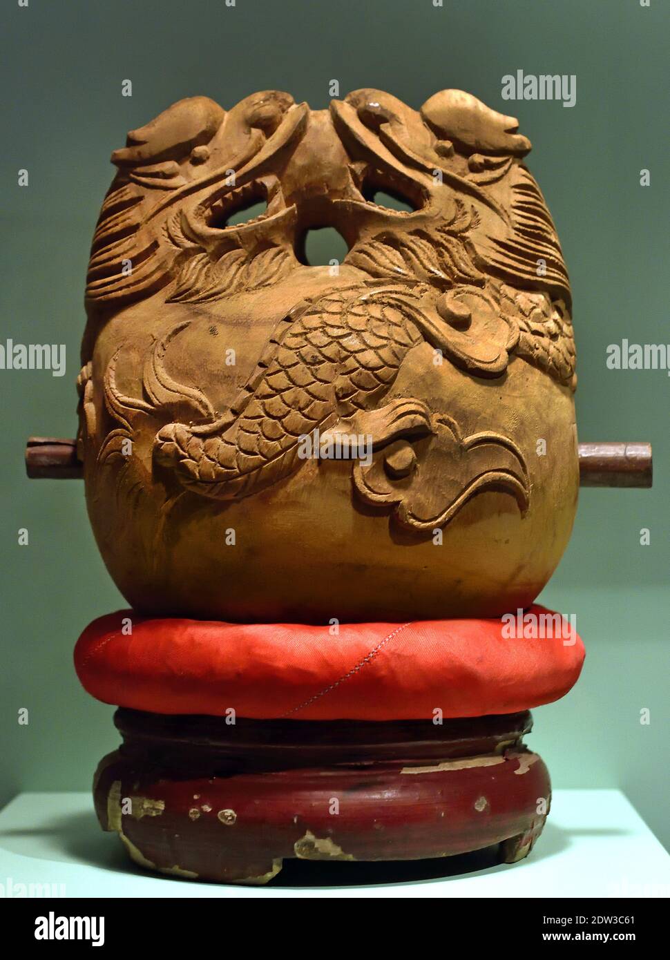 Bell with wooden striker ( wood Hanoi, North Vietnam, beginning 20th Century Vietnamese ( Two Dragons standing on the bell are holding a pearl. The Chinese motif refers to wisdom and Lightning ) Stock Photo