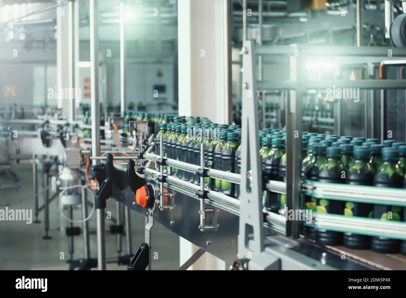 Industrial beverage factory interior. Conveyor with packaging of bottles with juice. Stock Photo