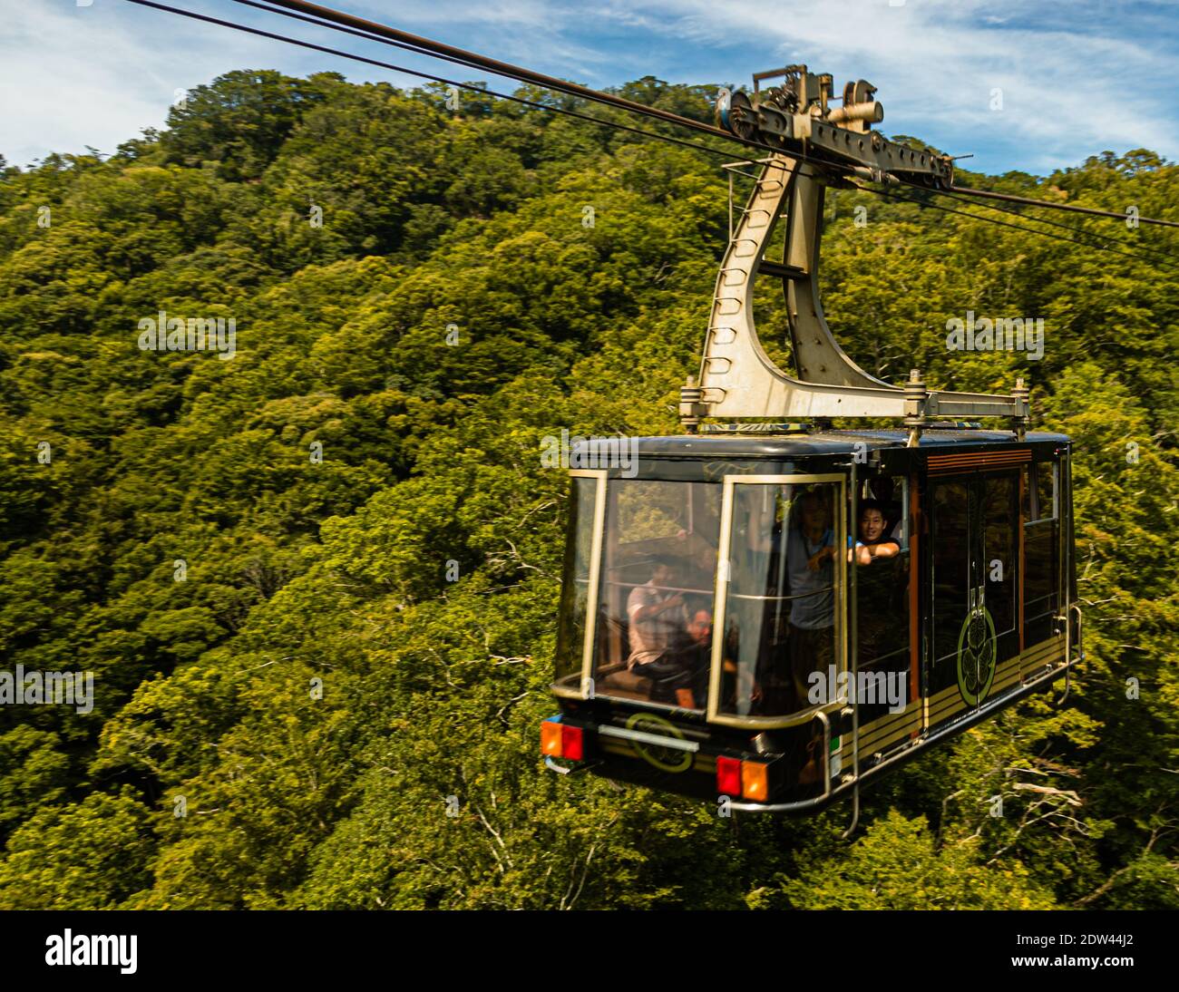 A cabin of the Nihondaira ropeway glides over dense mountain forest between the Nihondaira viewpoint hill and Kunōzan Tōshōgū shrine near Shizuoka, Japan – the shrine could formerly only be reached on foot via more than 1,000 stone steps. Stock Photo