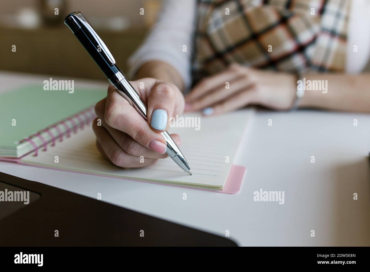 Young woman, student elearning distance training course work at home office and writing content on paper notebook with a pen while studying online Stock Photo