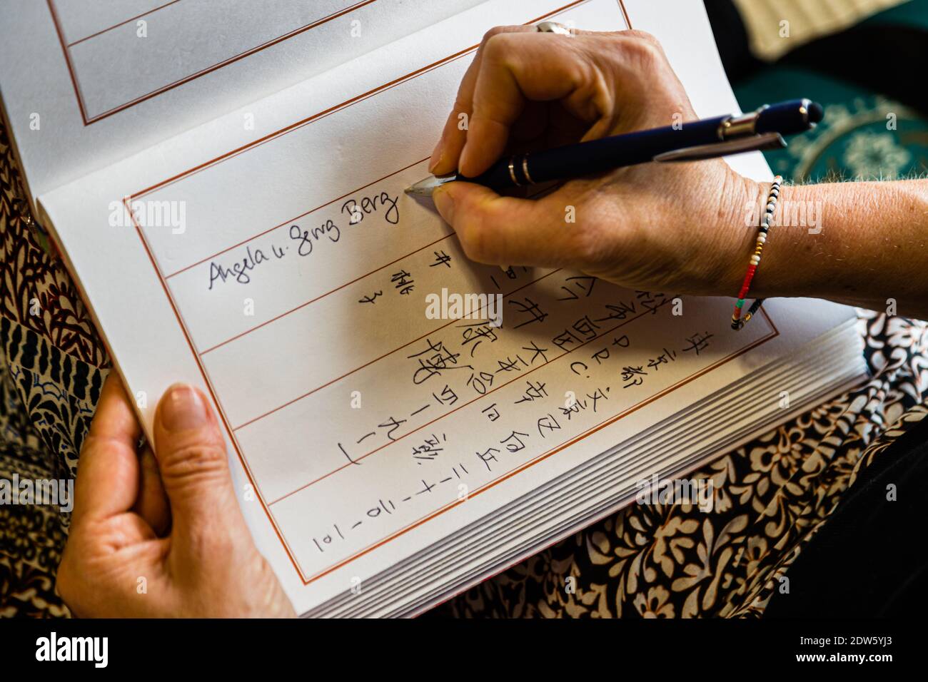 A hand writes "Angela u. Georg Berg" into the guestbook of the ryokan on Lake Hamana near Hamamatsu, Japan. Stock Photo