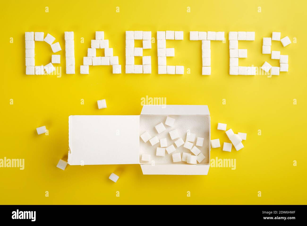 Word diabetes made from sugar cubes and an open pack of sugar cubes Stock Photo
