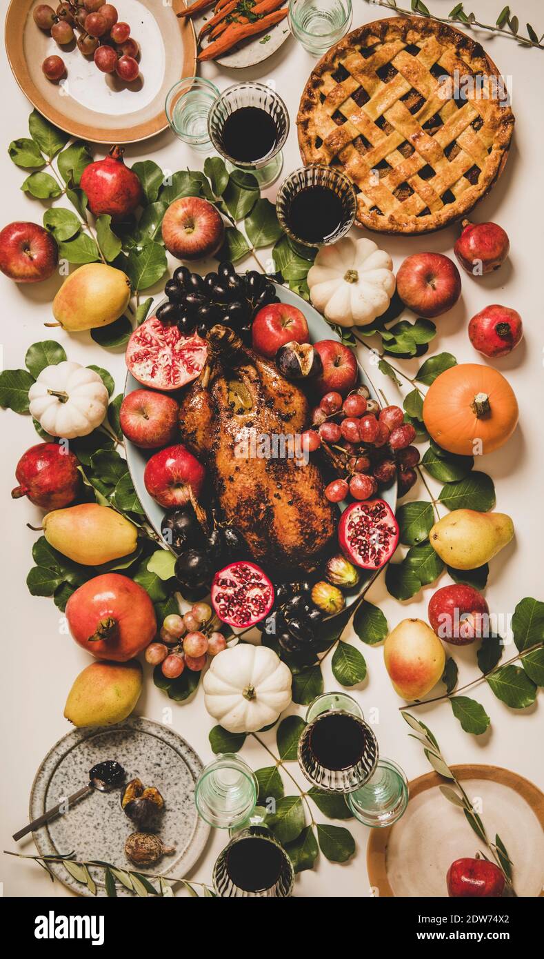 Autumn Thanksgiving, Friendsgiving, family party gathering celebration table setting. Flat-lay of Fall decorated table with roasted duck in fruits, ve Stock Photo